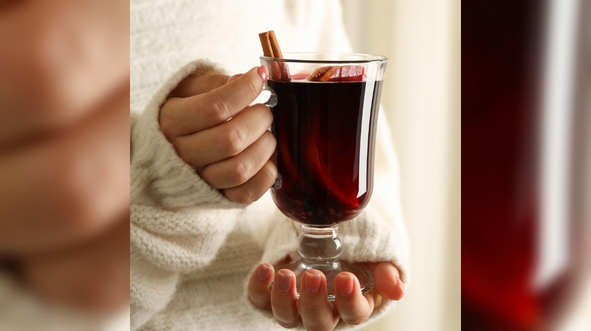 ženska, ki drži v roki kuhano vino