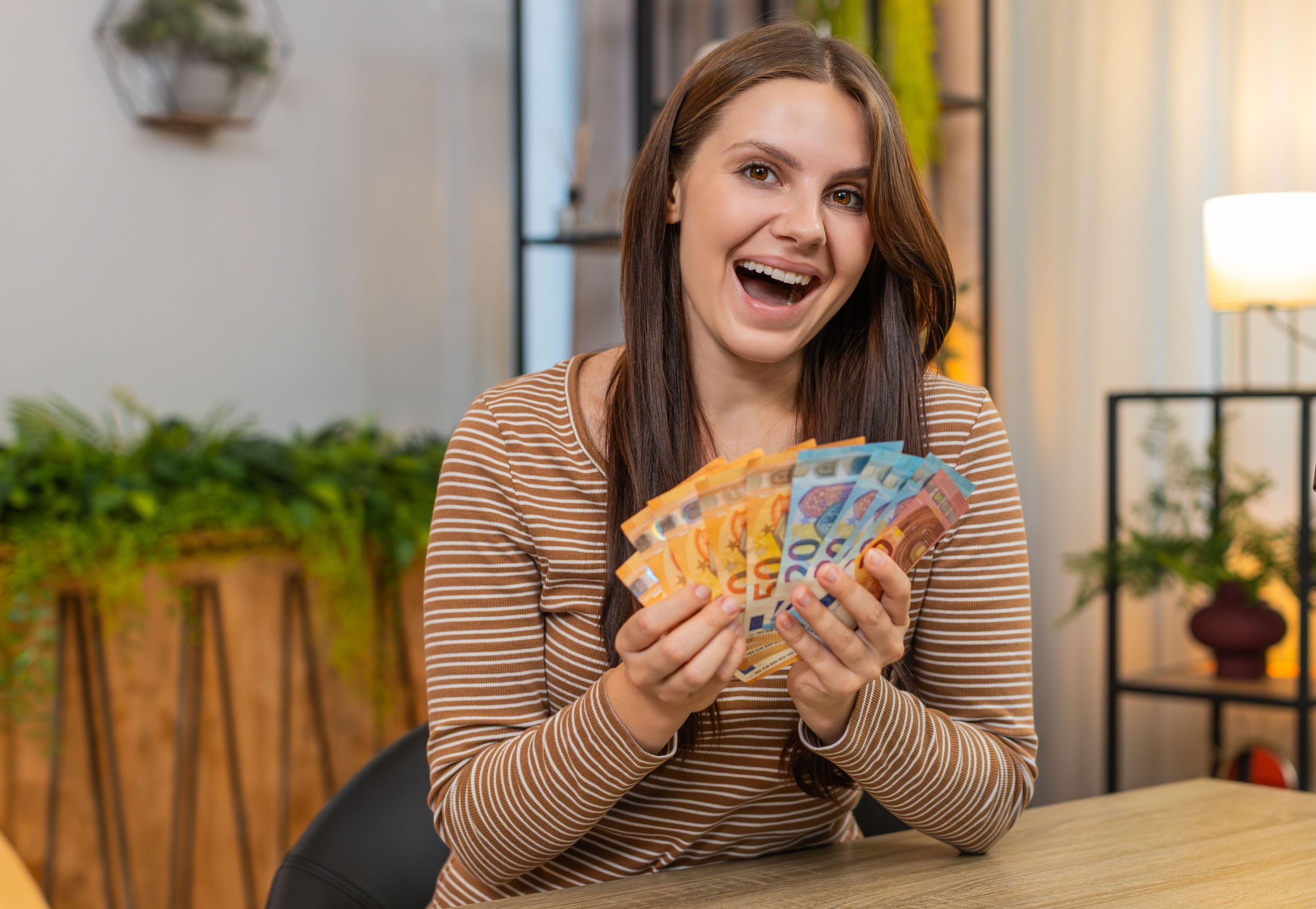 navdušena ženska z denarjem v roki