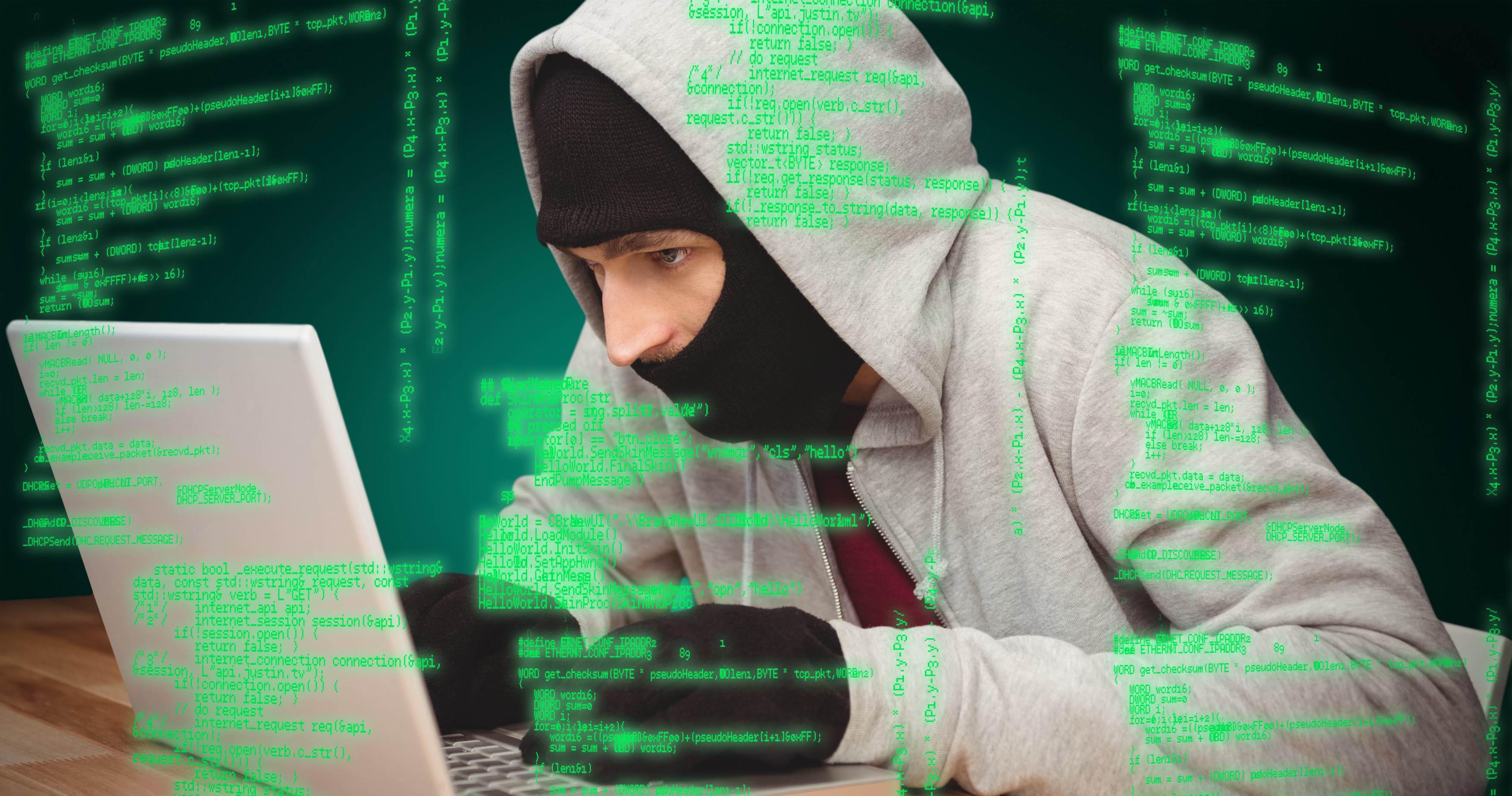 Hacker using laptop against green background with vignette,Image: 279948238, License: Royalty-free, Restrictions: , Model Release: yes
