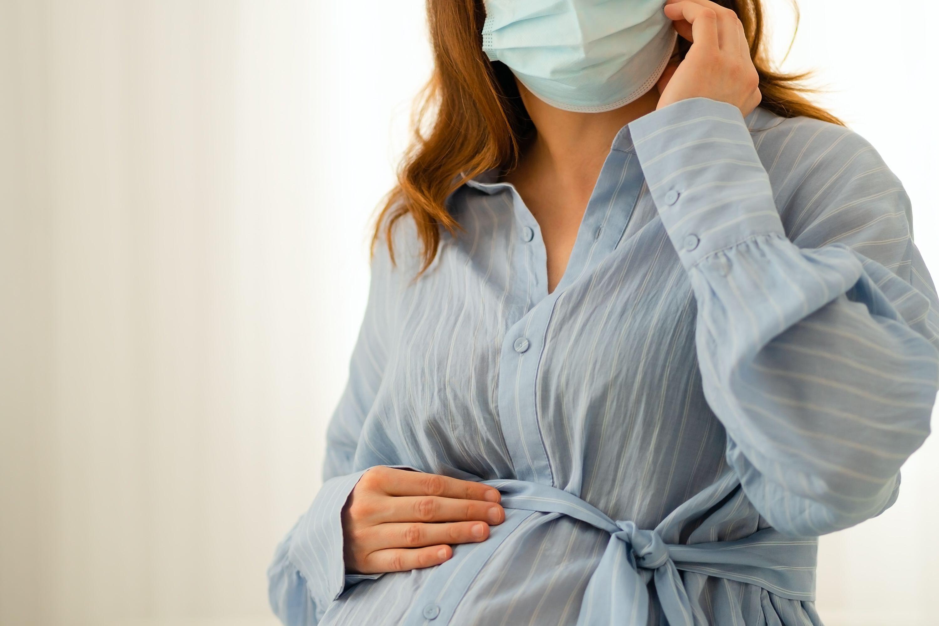 Expecting mother using medical mask as preventive measure. Responsible approach to infection control during gestation.,Image: 1016893958, License: Royalty-free, Restrictions: , Model Release: yes