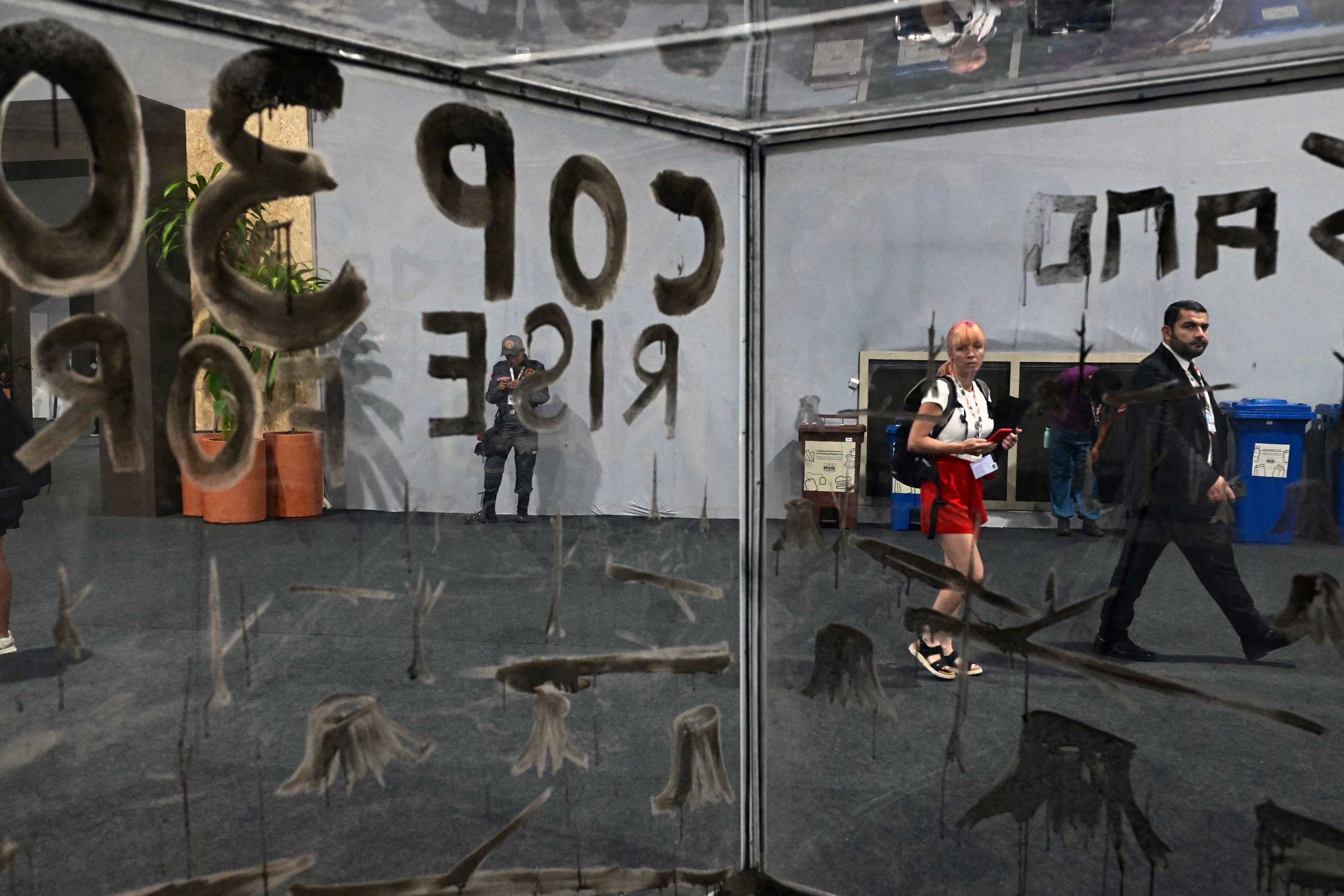 People walk past an installation by Brazilian artist Mundano,