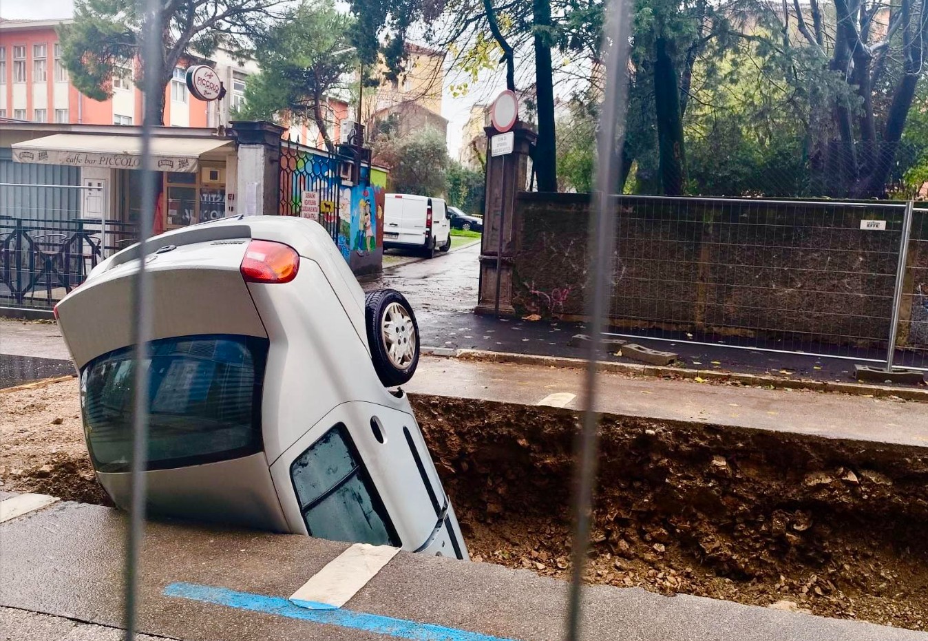 Avto, ki se je zvrnil v luknjo, ki so jo na Reki (Rijeki) izkopali komunalci