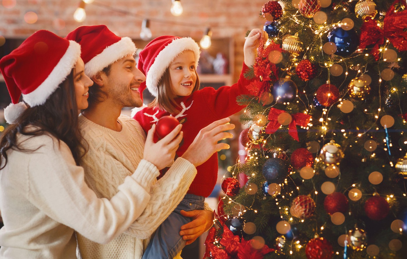 družina krasi božično drevesce