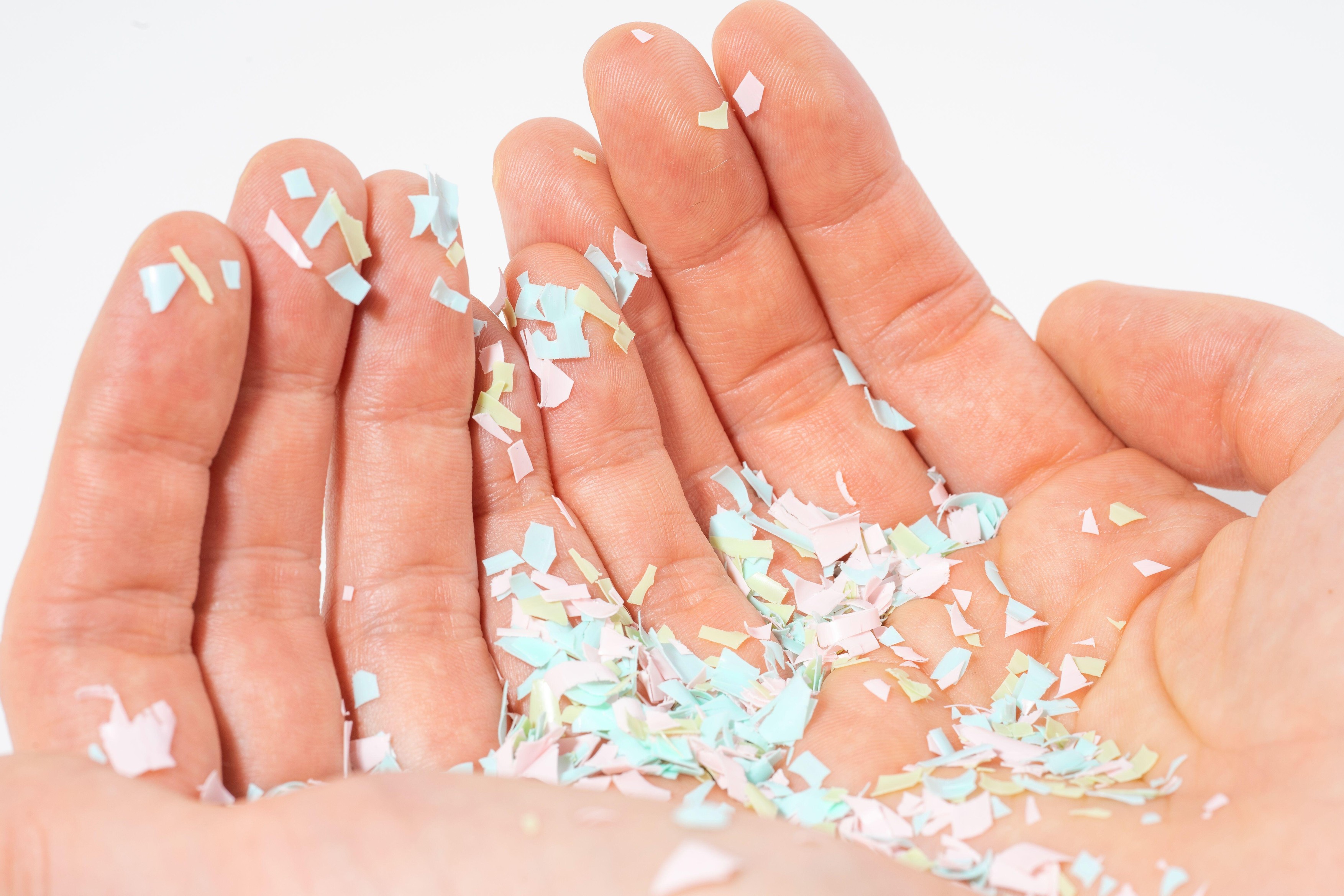 A close-up photo of microplastics lay on human hand. Concept of water pollution and global warming. The idea of environmental damage. White background.,Image: 687935025, License: Rights-managed, Restrictions: , Model Release: no