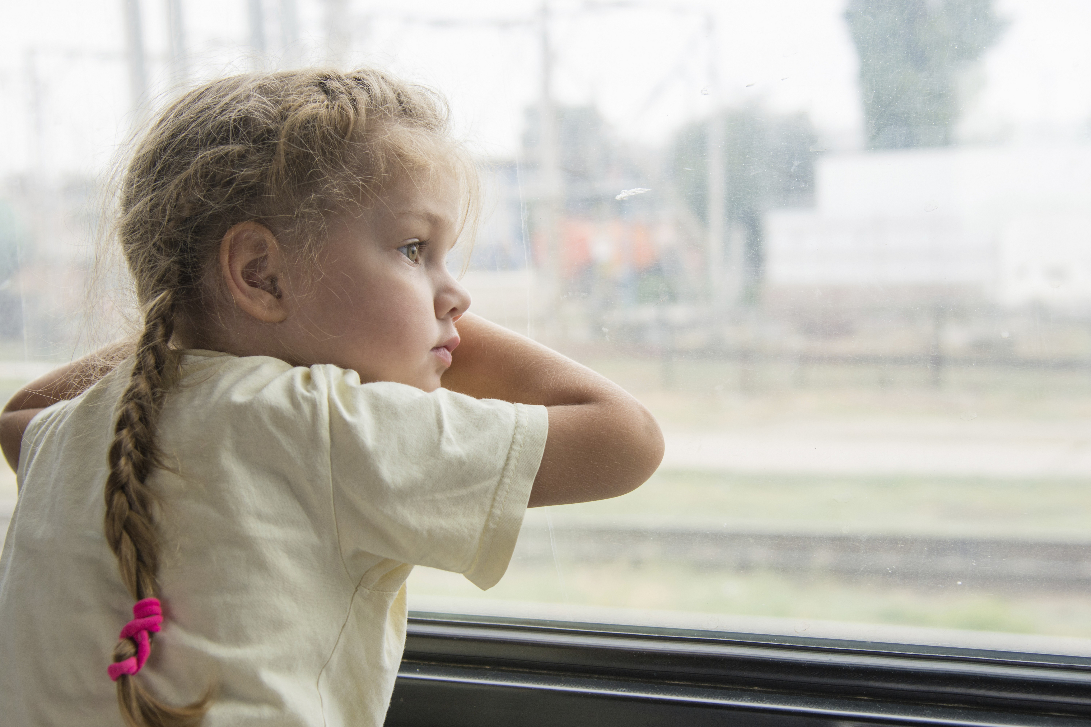 Four-year girl looking out the window with the bottom side of the shelf in the second-class train carriage,Image: 1004528148, License: Royalty-free, Restrictions: , Model Release: yes