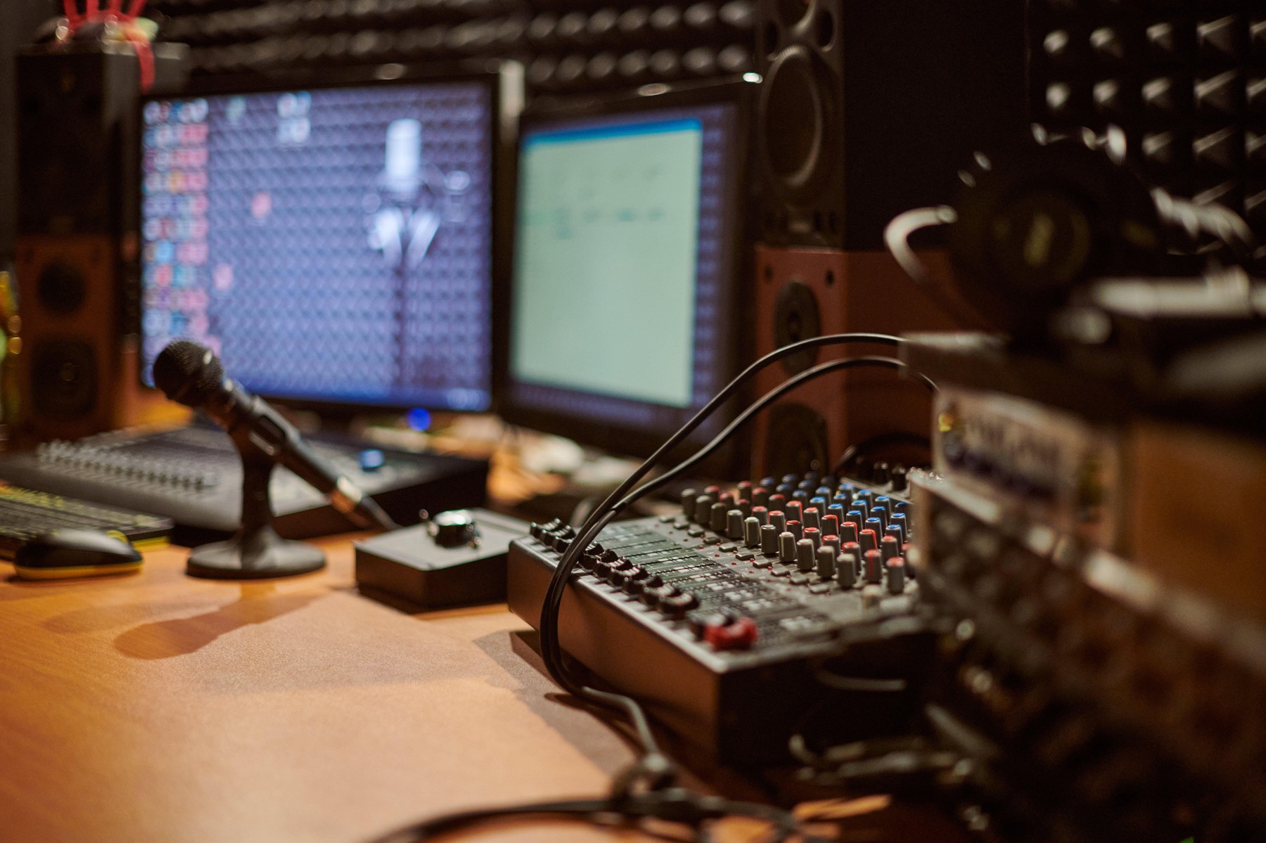 Audio mixing console with microphone in contemporary recording studio setting, showcasing intricate connections and advanced technology used in sound