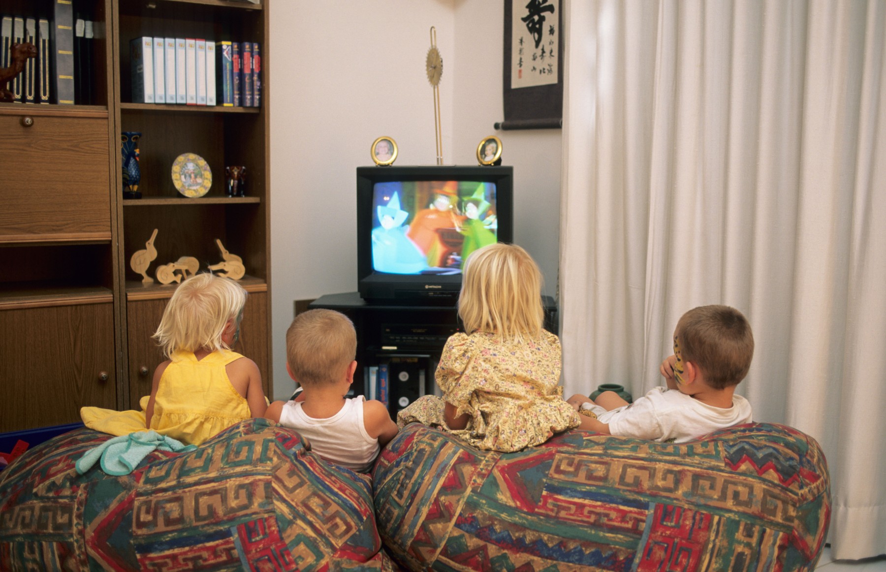 Children watching TV on couch.