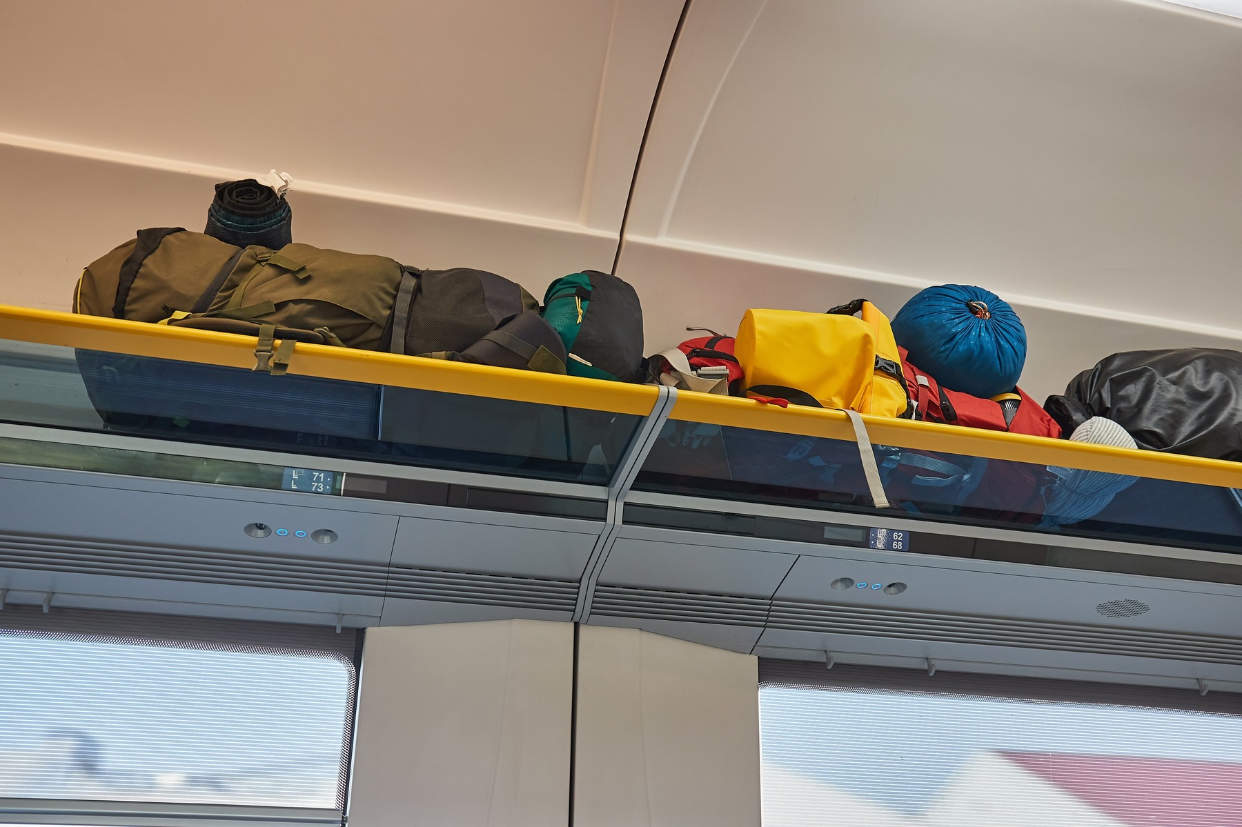 Passenger Train interior with bags on the luggage shelf