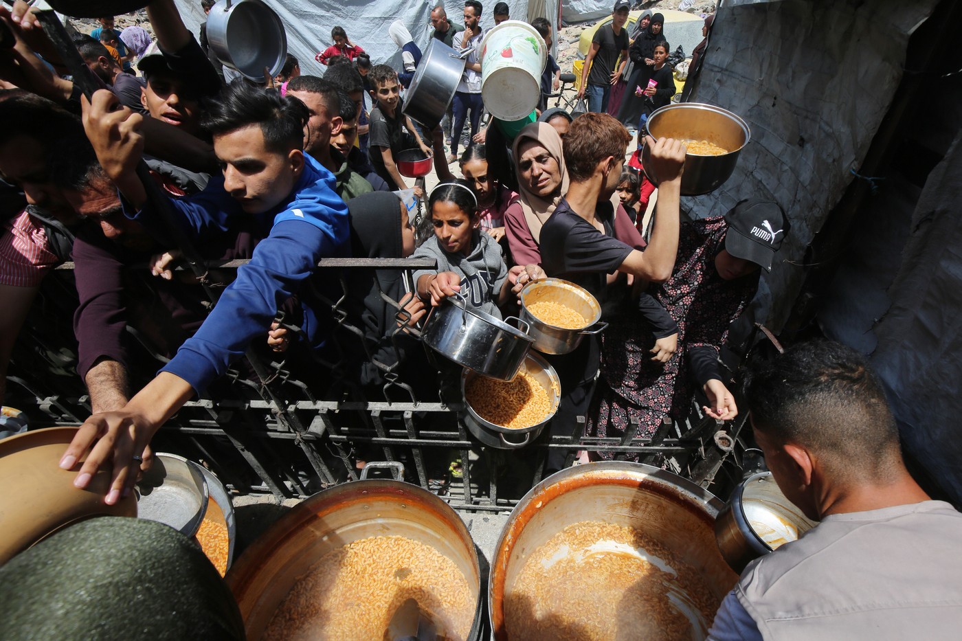 Palestinians, mostly children, wait in long lines with empty pots in hands to get a warm meal distributed, Beit Lahia, Gaza Strip, Palestinian Territory - 03 May 2025