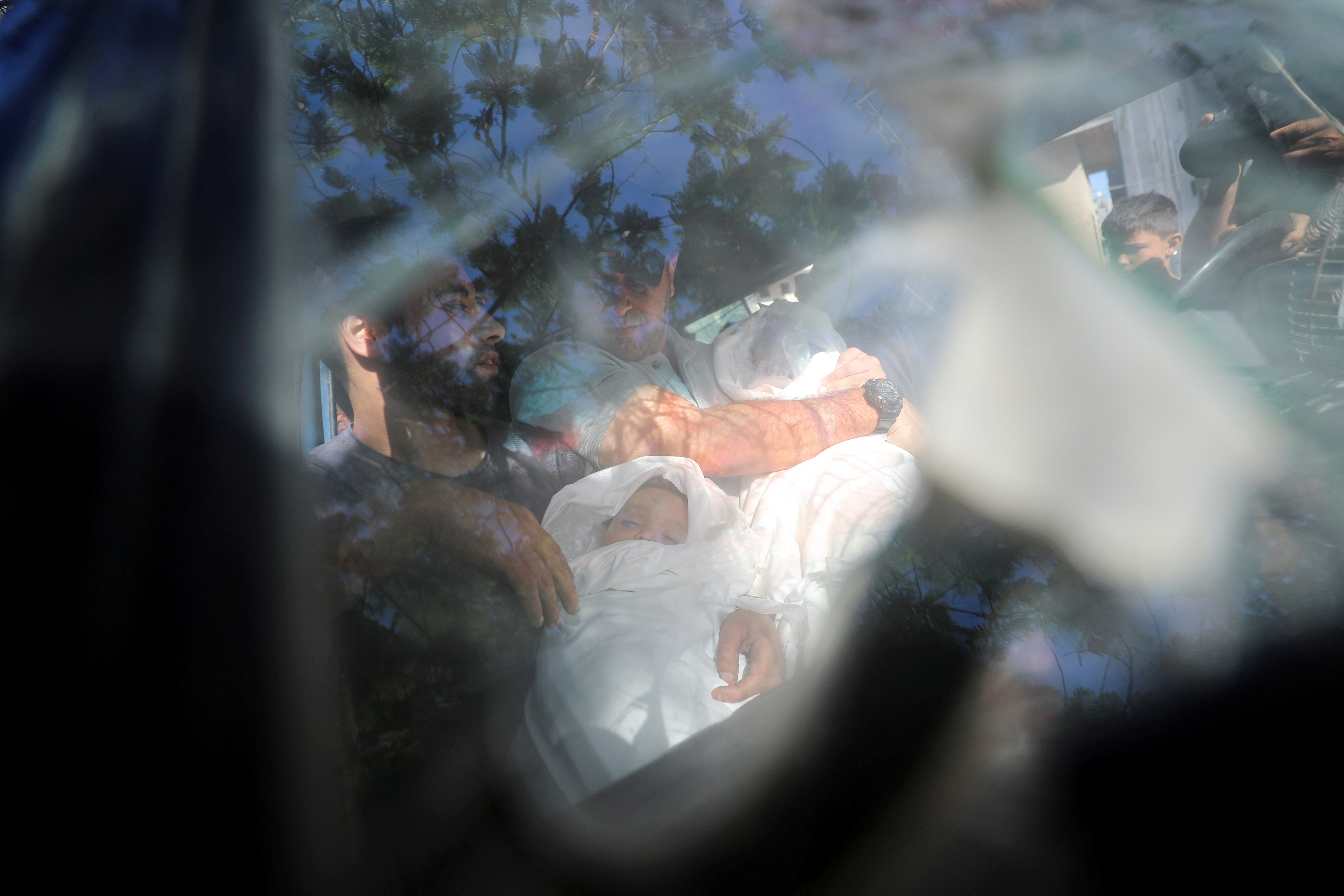 Možje na poti na pogreb pestujejo trupla otrok, ki so bili ubiti v mestu Gaza