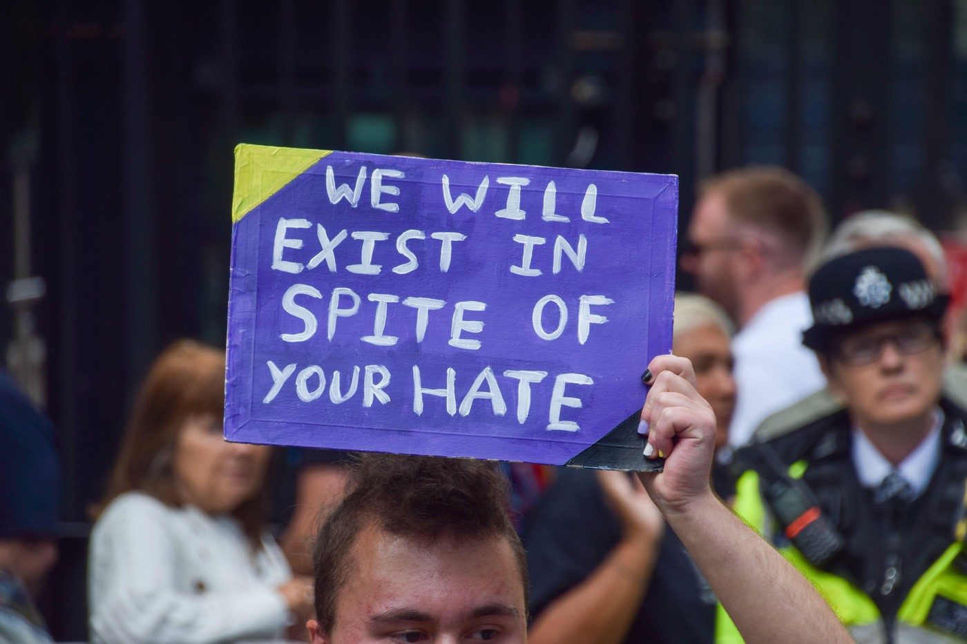 Plakat v angleščini: "Obstajali bomo navkljub vašemu sovraštvu."