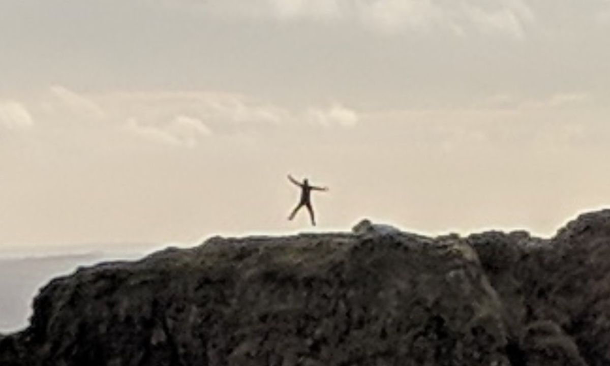 Moški je posnel fotografijo, ki je ujela trenutek, ko je moški v daljavi skočil v zrak