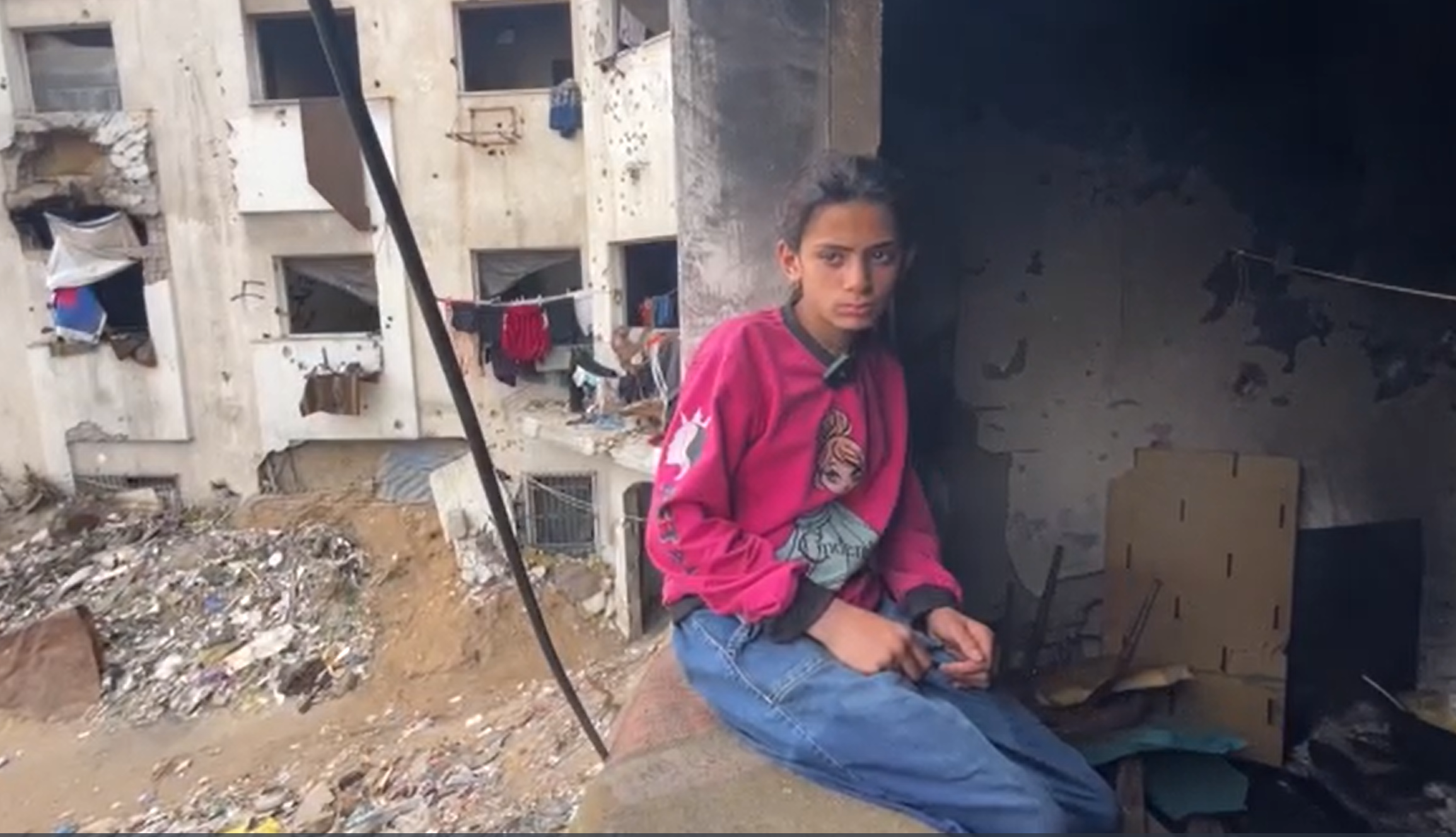 12-letna deklica Jana iz Gaze sedi ob ruševinah.