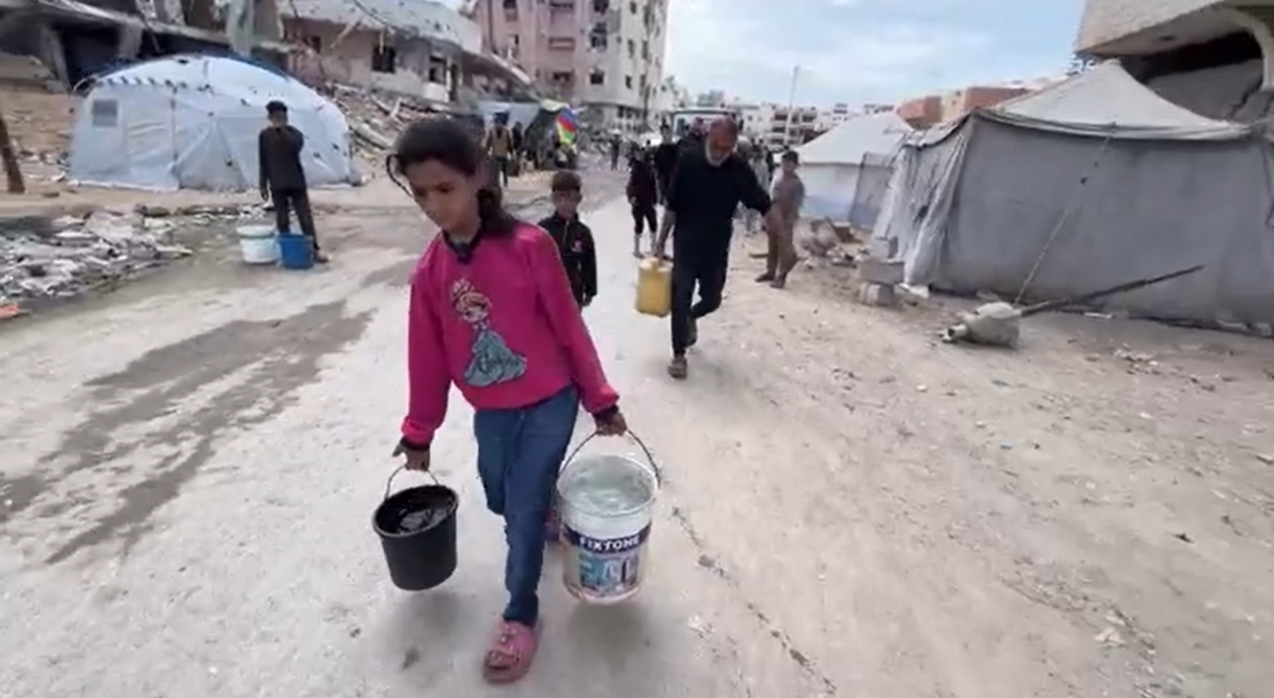 Deklica Jana iz Gaze nosi vodo