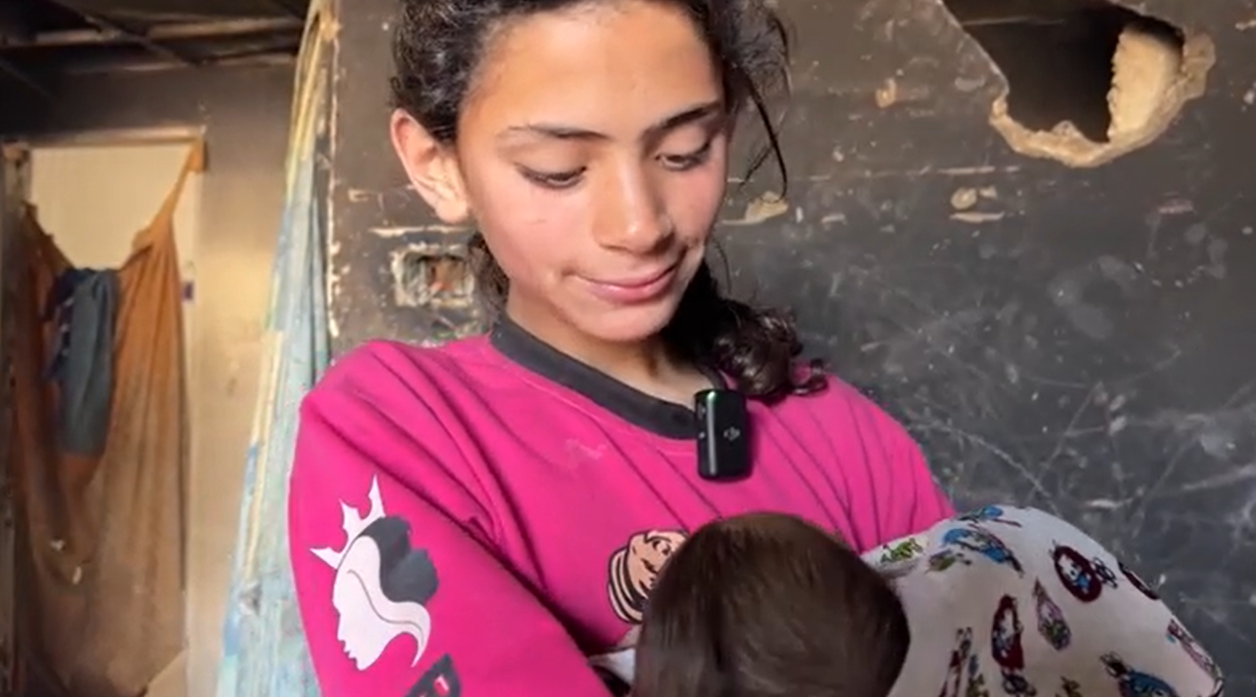 12-letna deklica Jana iz Gaze v naročju drži dojenčka