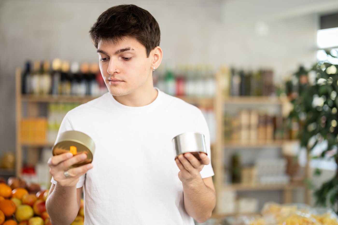 Moški si ogleduje konzerve s hrano