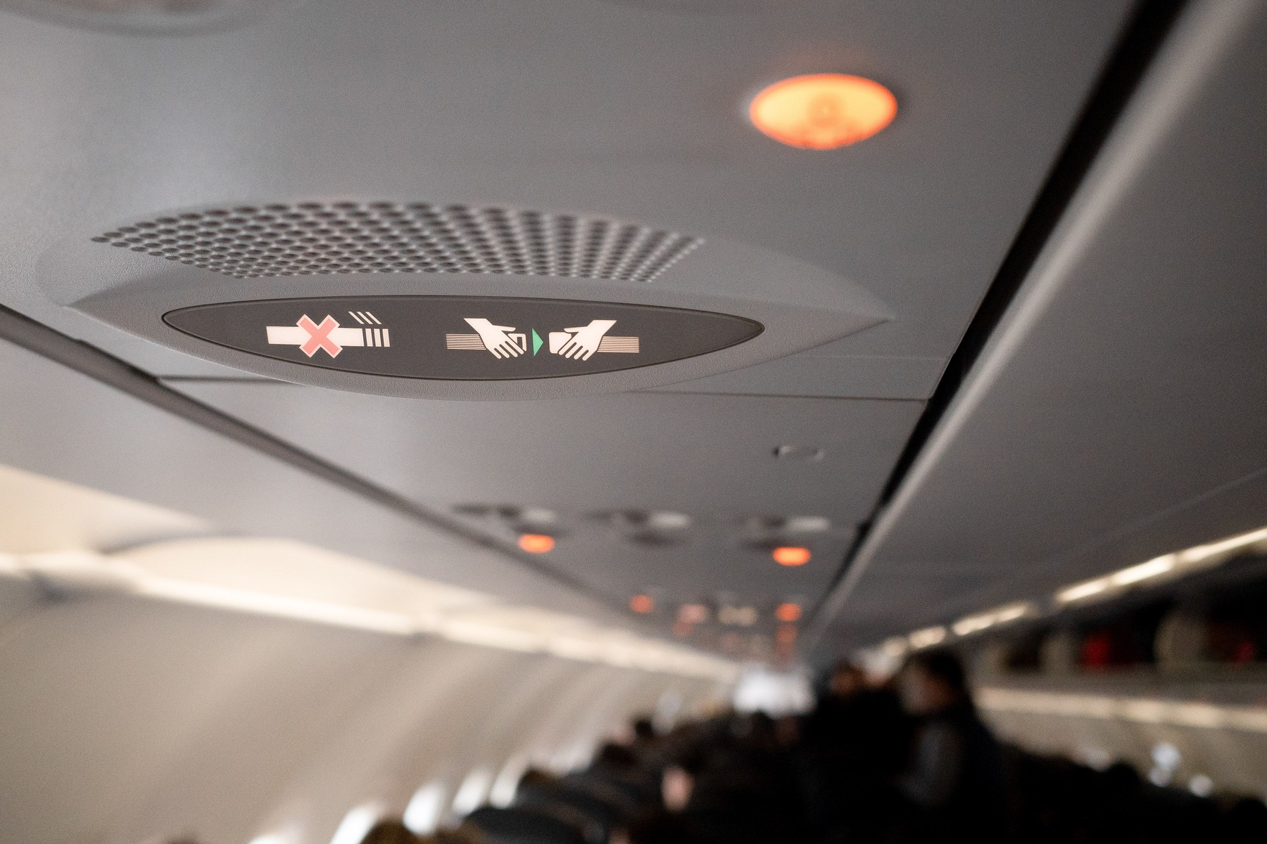 Znak na letalu, ki opozarja, da je prepovedano kajenje in obvezno pripenjanje pasu.