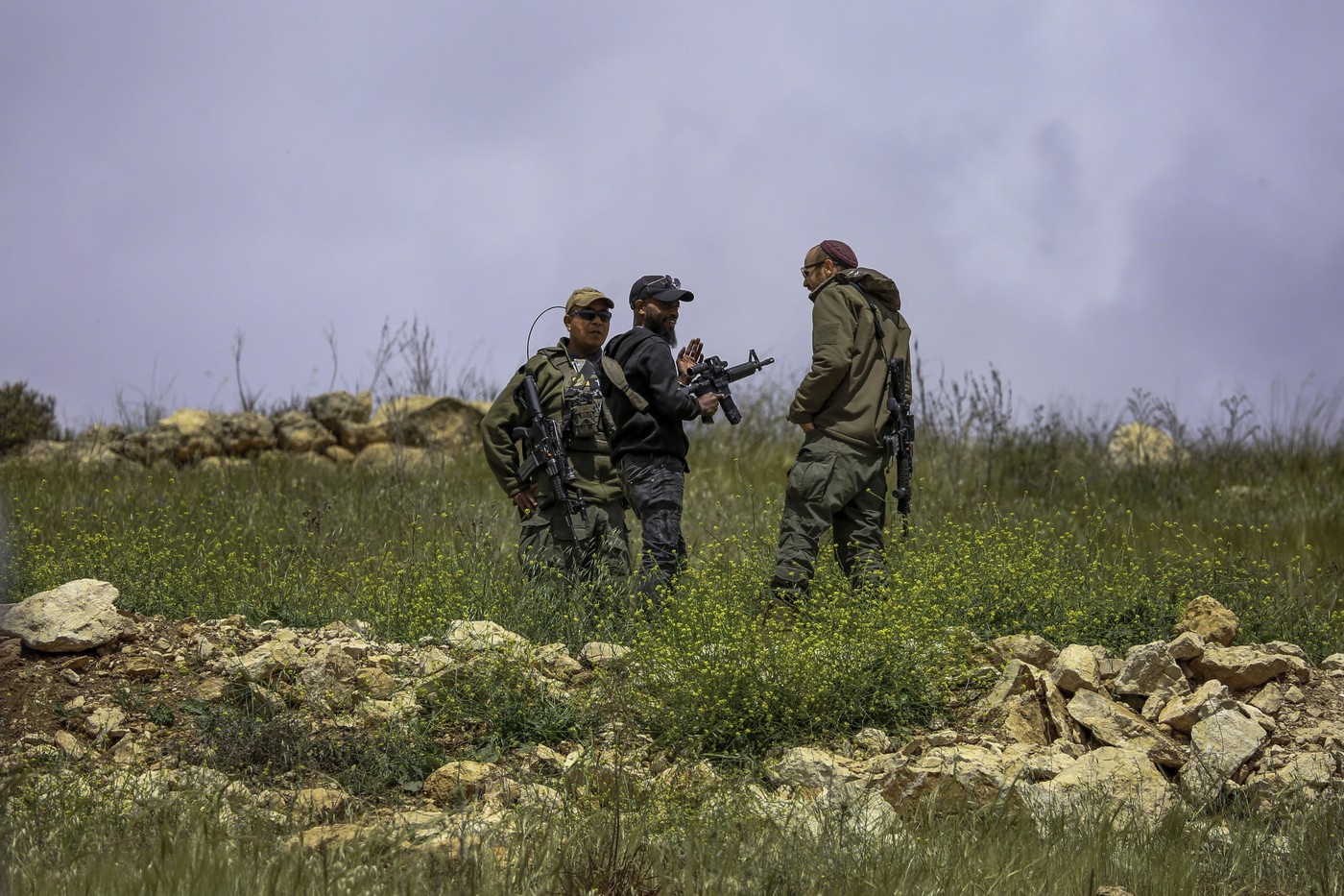 Oboroženi naseljenec in izraelska vojaka v Hebronu na Zahodnem bregu, potem ko so uničili tri hiše in pregnali 30 Palestincev, ki so živeli v njih. Hebron, april 2025.