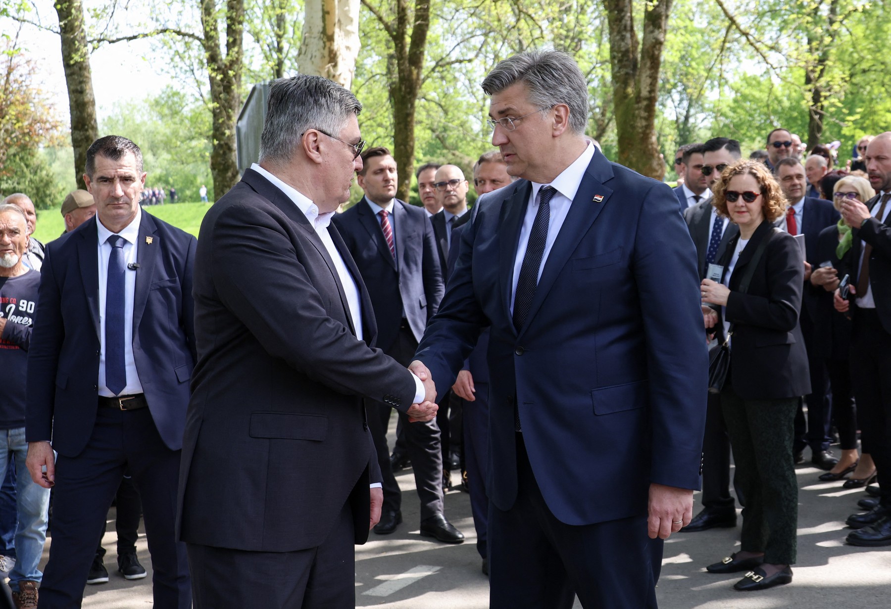 Milanović in Plenković se rokujeta na prireditvi.