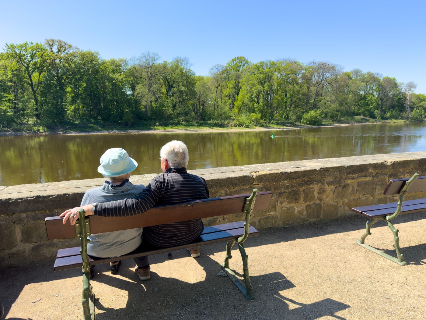 Starejši par poseda ob reki.