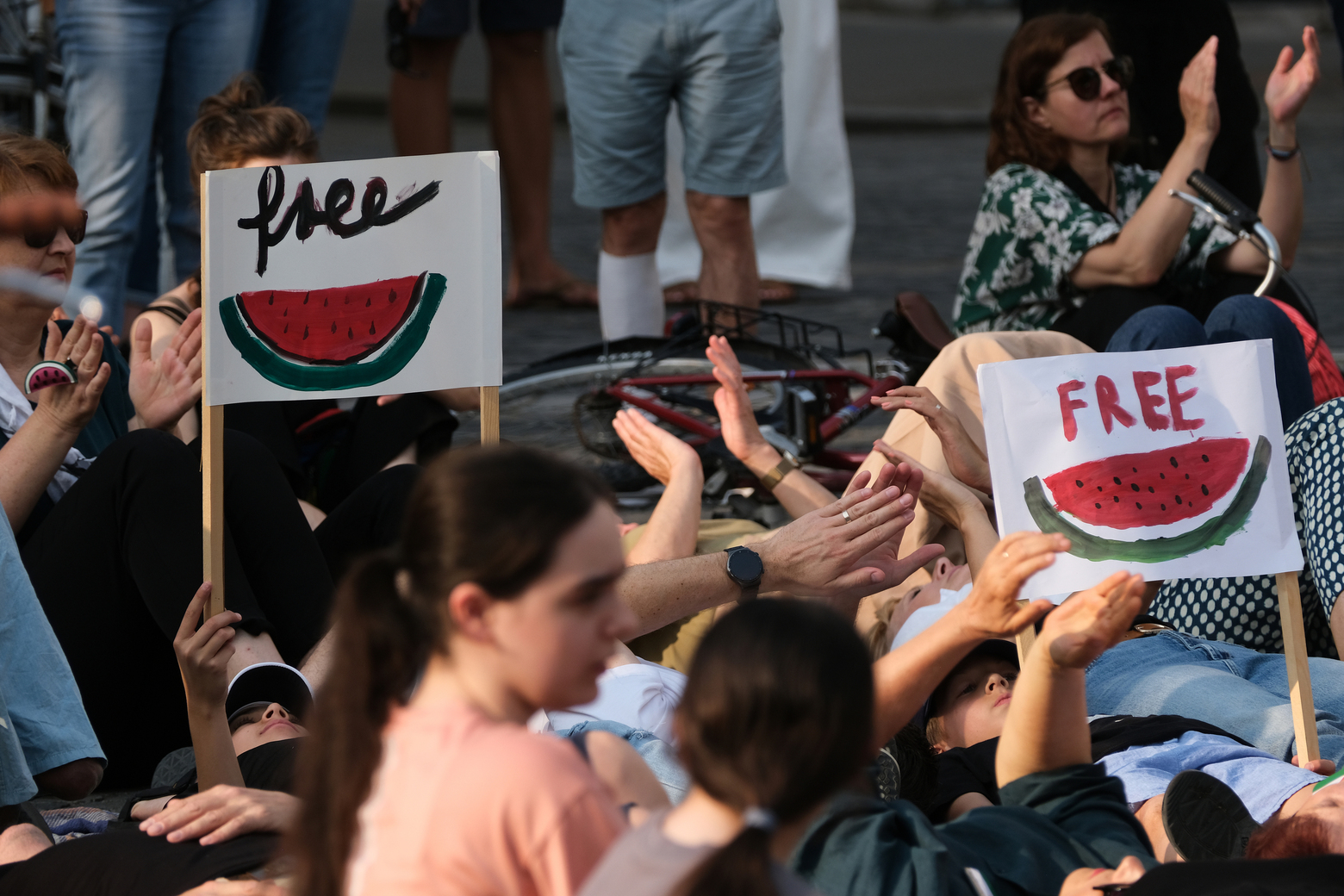 Ljudje ležijo na tleh v okviru protestnega shoda "Obležimo za Palestino"