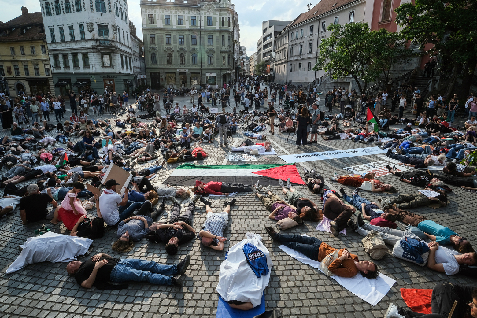 Ljudje ležijo na tleh v okviru protestnega shoda "Obležimo za Palestino"
