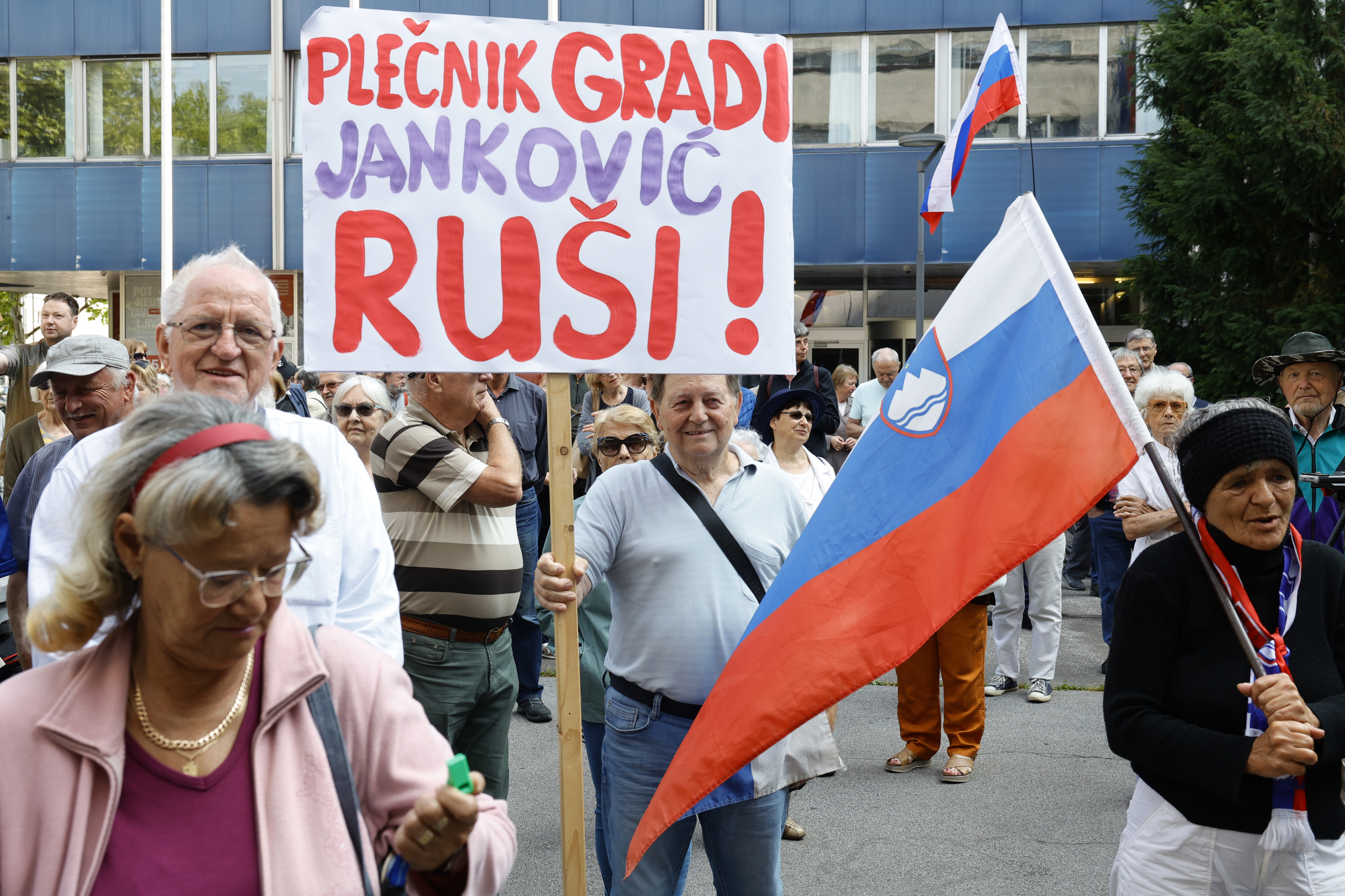 Protestnik s plakatom z napisom "Plečnik gradi, Janković ruši"