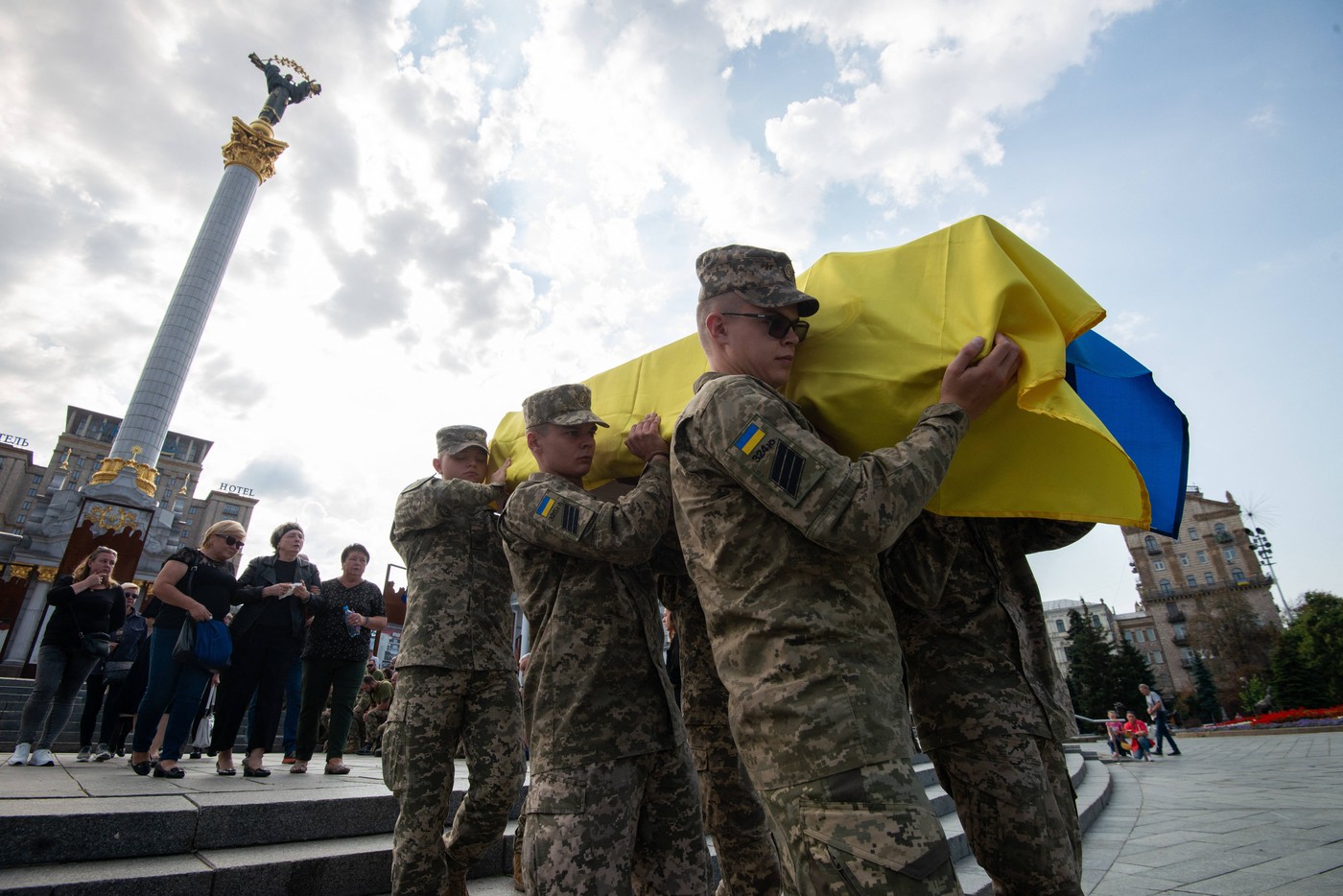 Vojaki nosijo krsto prekrito z ukrajinsko zastavo