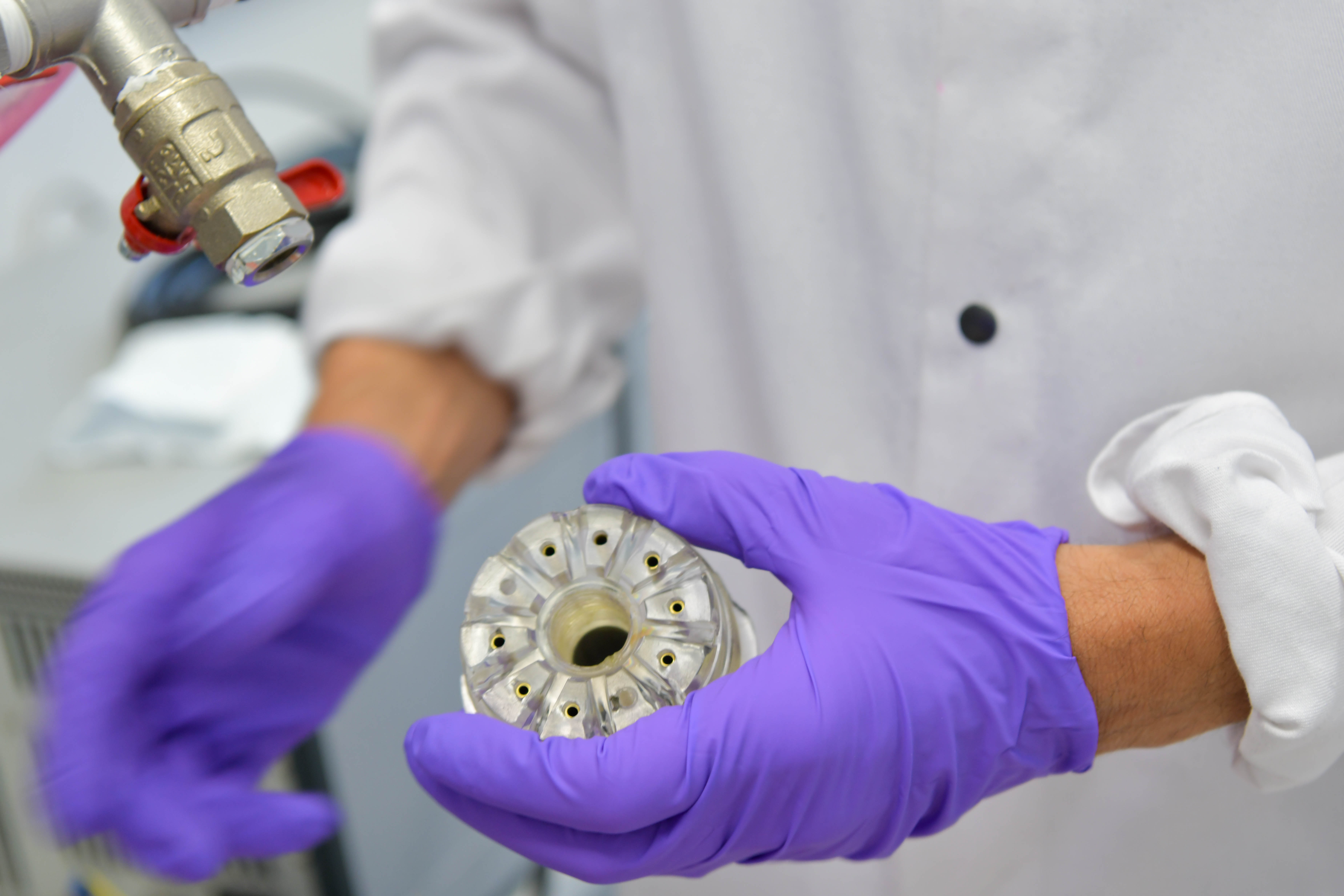 Raziskovalec v rokah drži del naprave