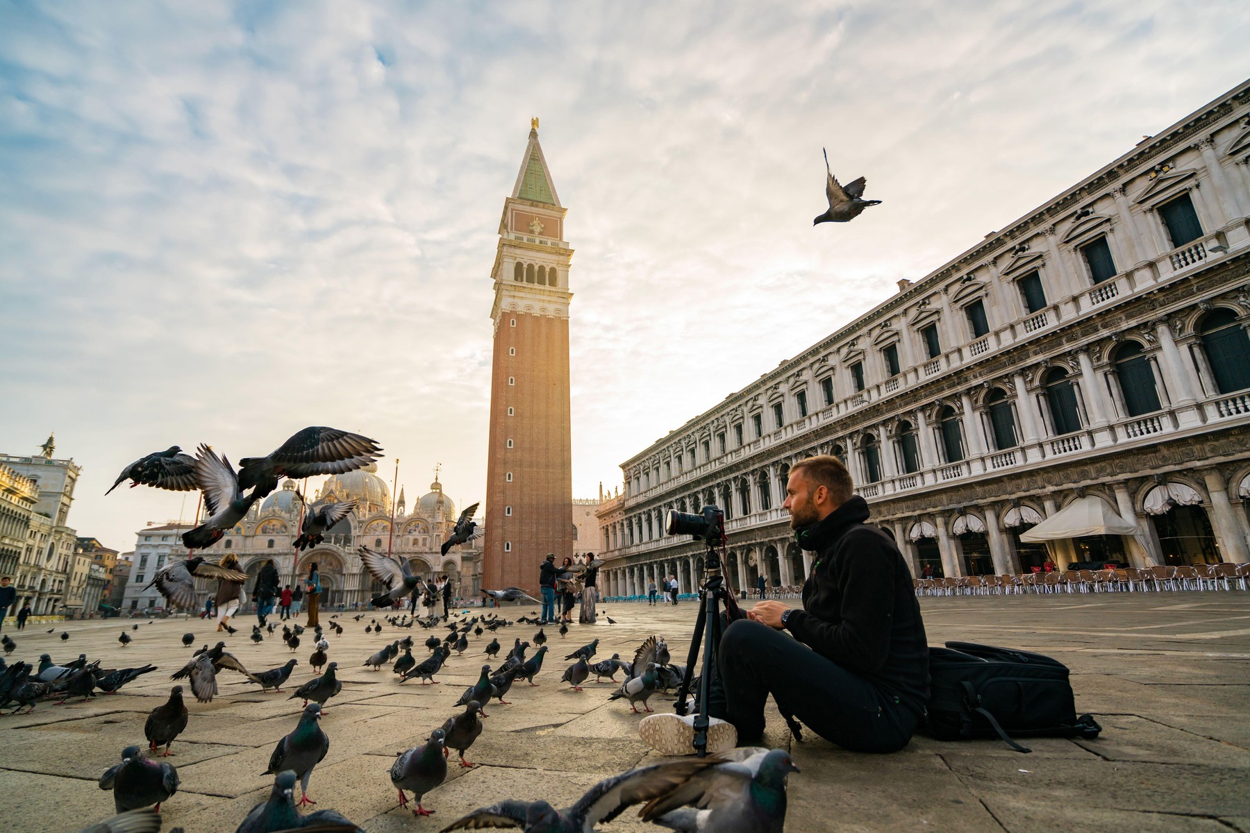 Moški fotografira golobe v Benetkah