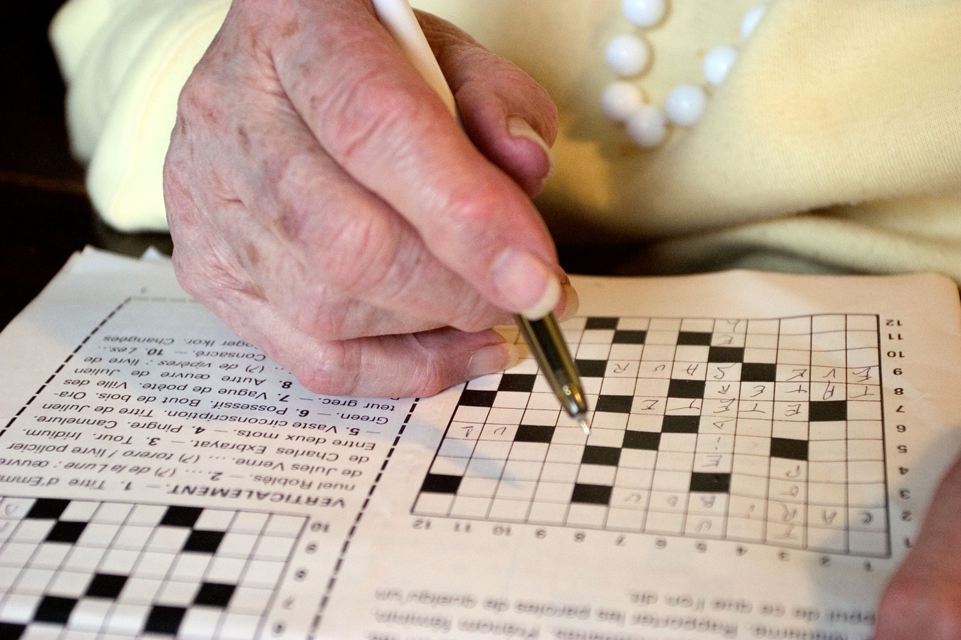 Starejša ženska rešuje križanke
