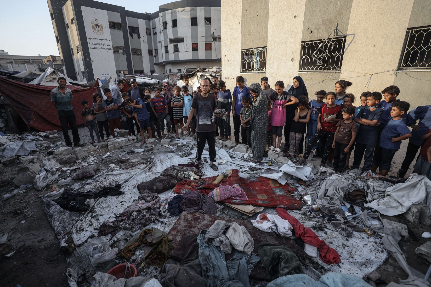 GAZA CITY,AUGUST 20: Palestinians, including children, inspect the makeshift tent targeted by the Israeli army in front of the Islamic University of Gaza on August 20, 2025