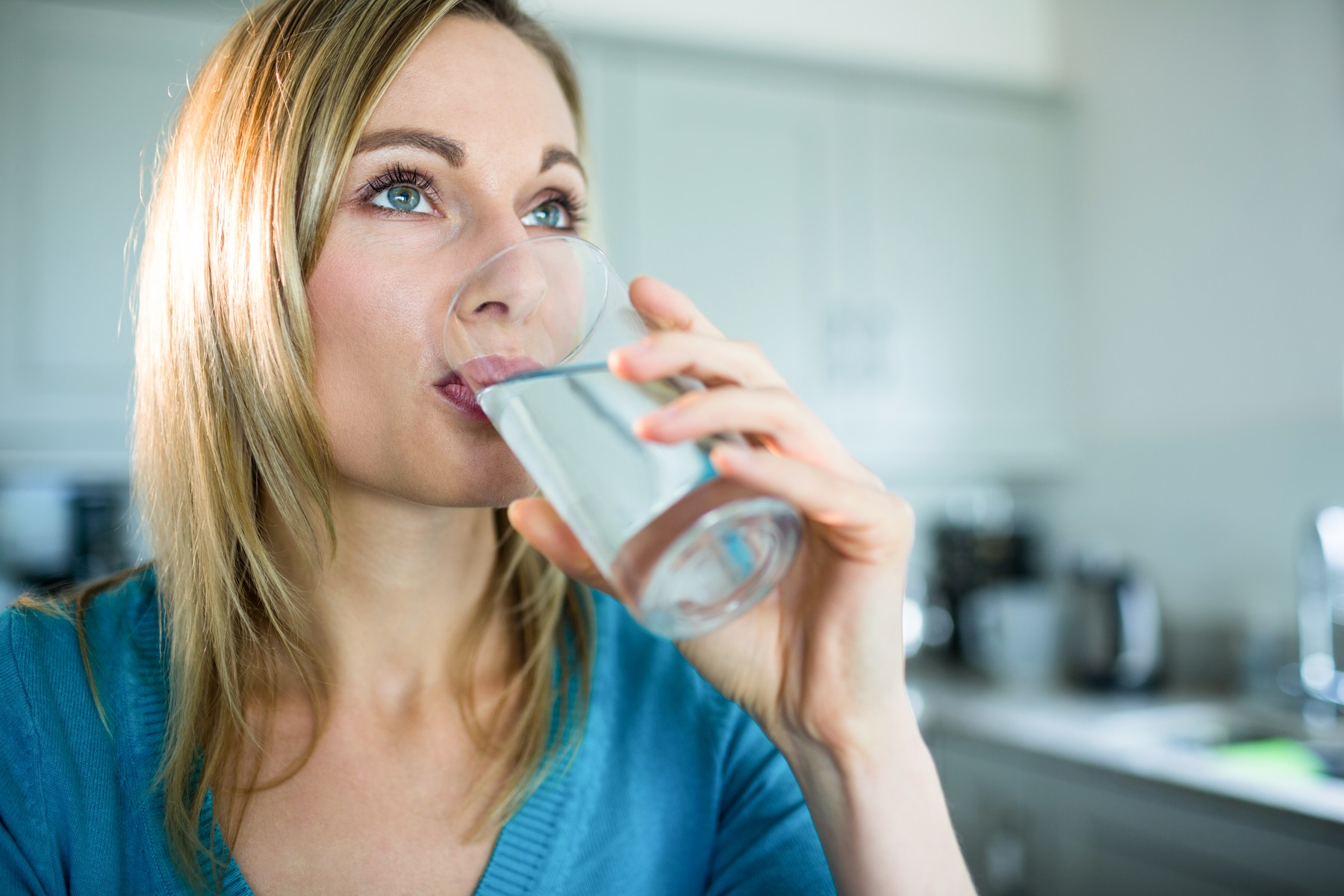 Pretty blonde woman drinking a glass of water at home,Image: 279967702, License: Royalty-free, Restrictions: , Model Release: yes
