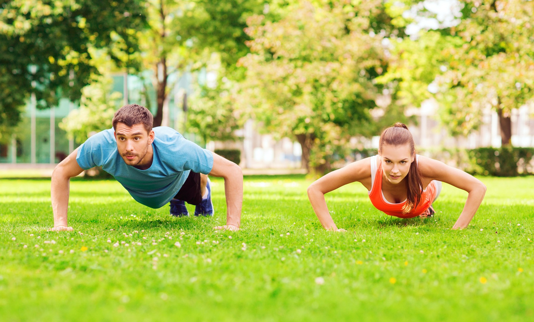 fitness, sport, training and lifestyle concept - couple doing push-ups outdoors,Image: 204727909, License: Royalty-free, Restrictions: , Model Release: yes