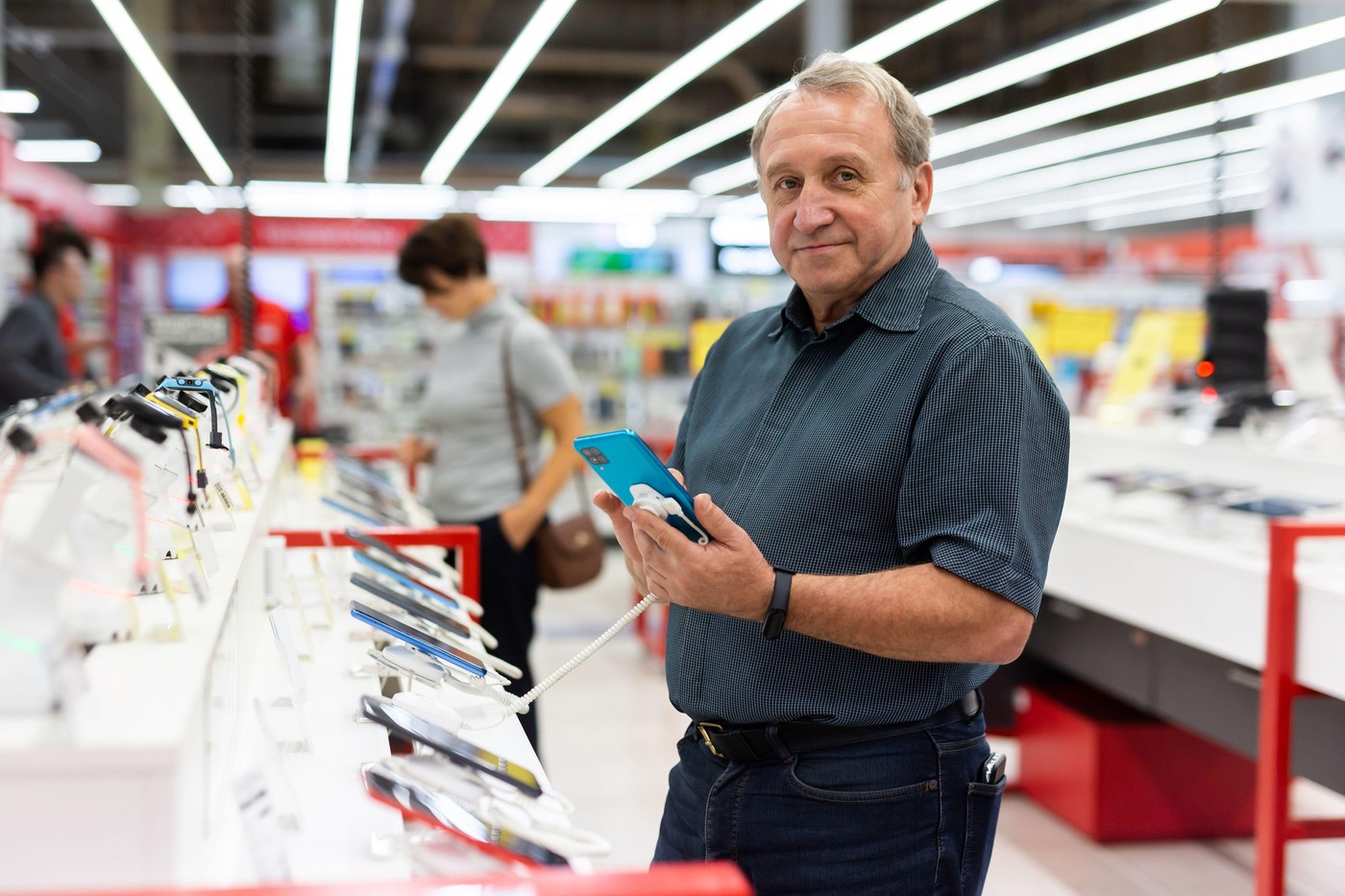 moški izbira mobilni telefon v trgovini