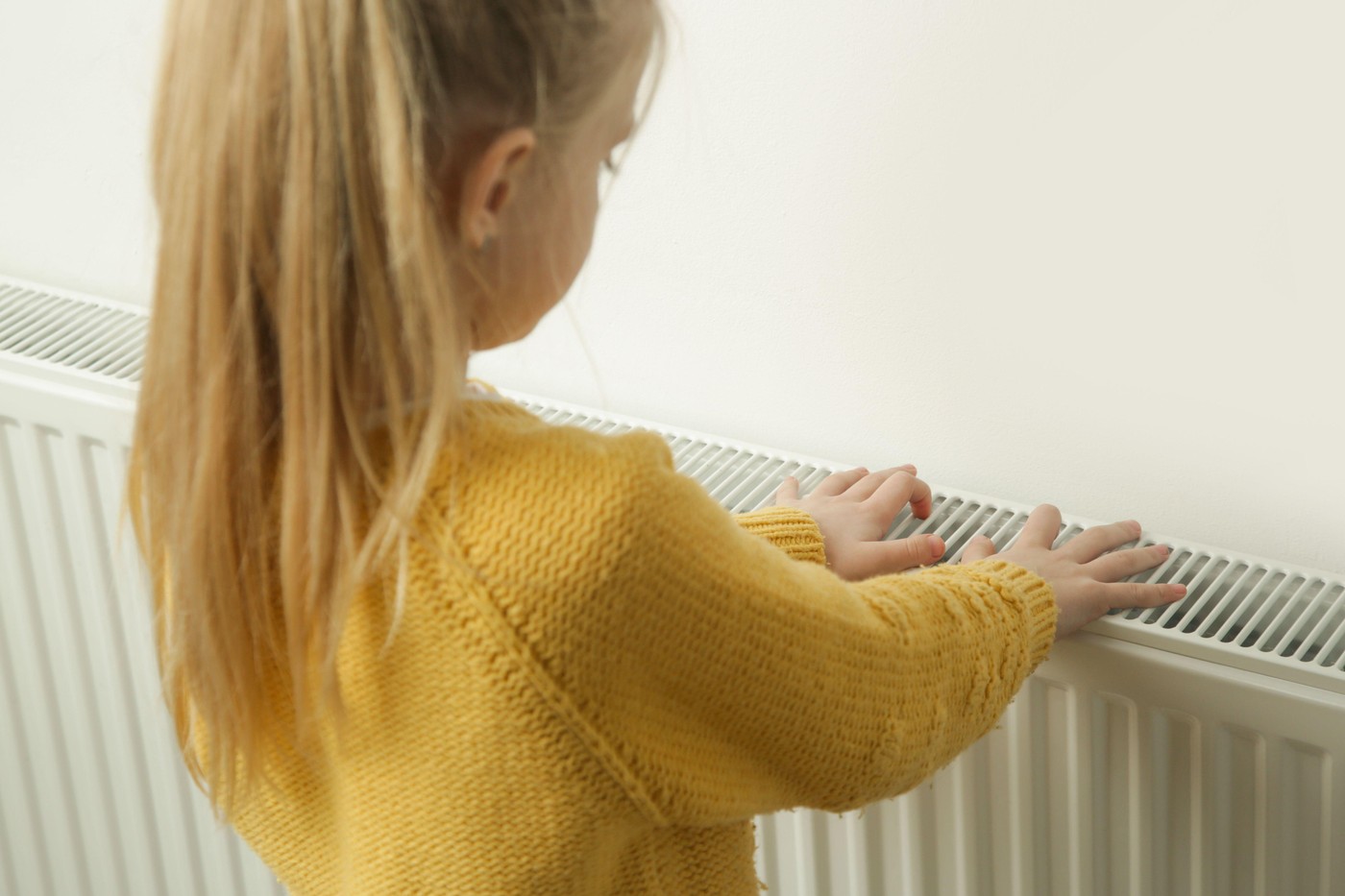 Otrok ob radiatorju