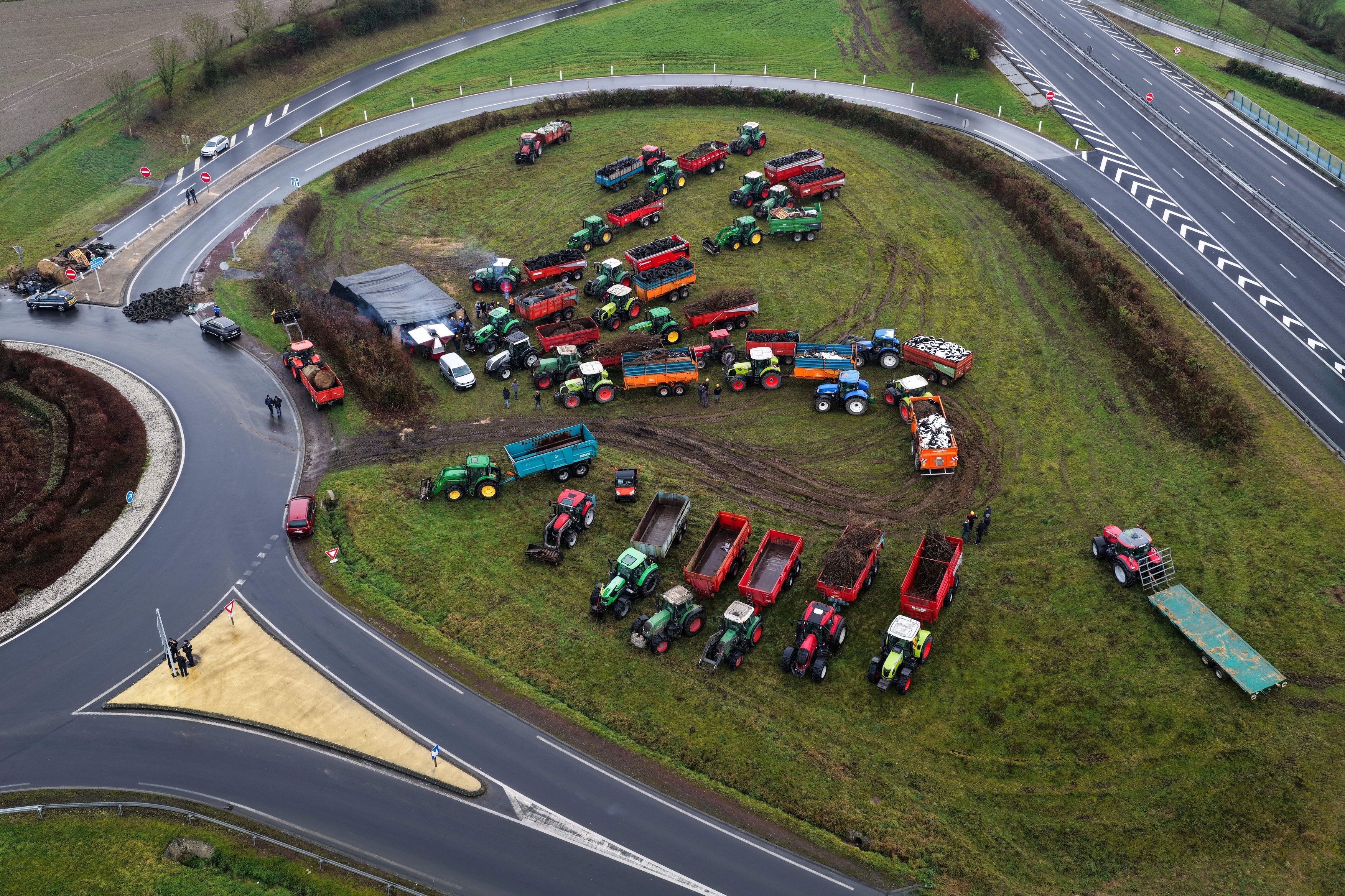 An aerial photograph taken on January 5, 2026 shows farmers taking part, with their vehicles, in a blockade of the A84 highway entrance in Poilley, western France, as part of a series of action called in the region by French farmer union