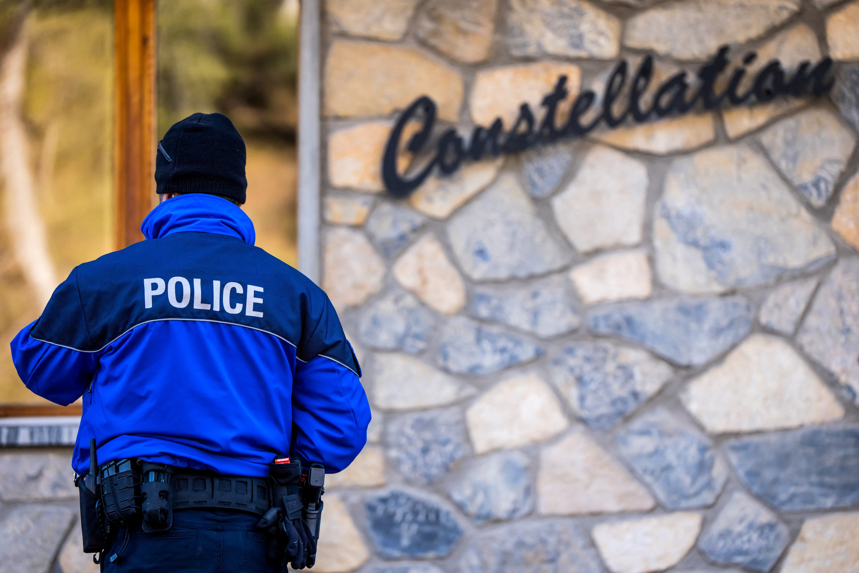 A police officers stands at the entrance of the building Constellation, housing the bar Le Constellation following a fire that ripped through the venue in Crans-Montana, in January 1, 2026 during New Year's Eve celebrations.