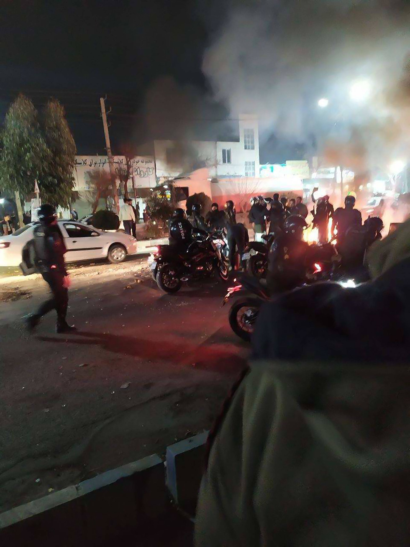 Tehran, District Shahriar, Iran, 08/01/2026 – Thick smoke rises as demonstrators and