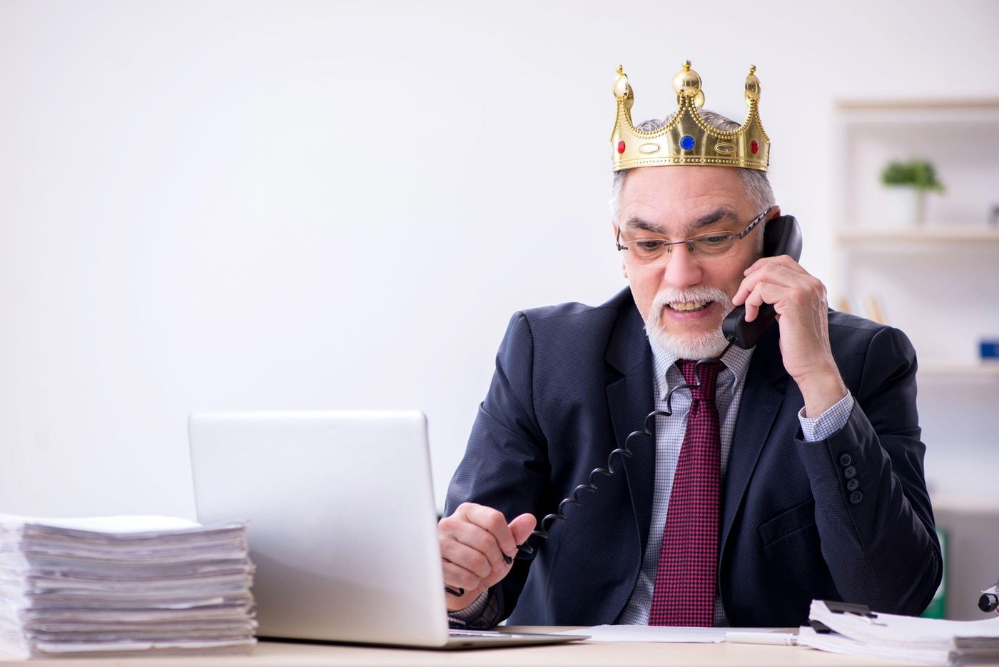 starejši moški poslovnež s krono na glavi