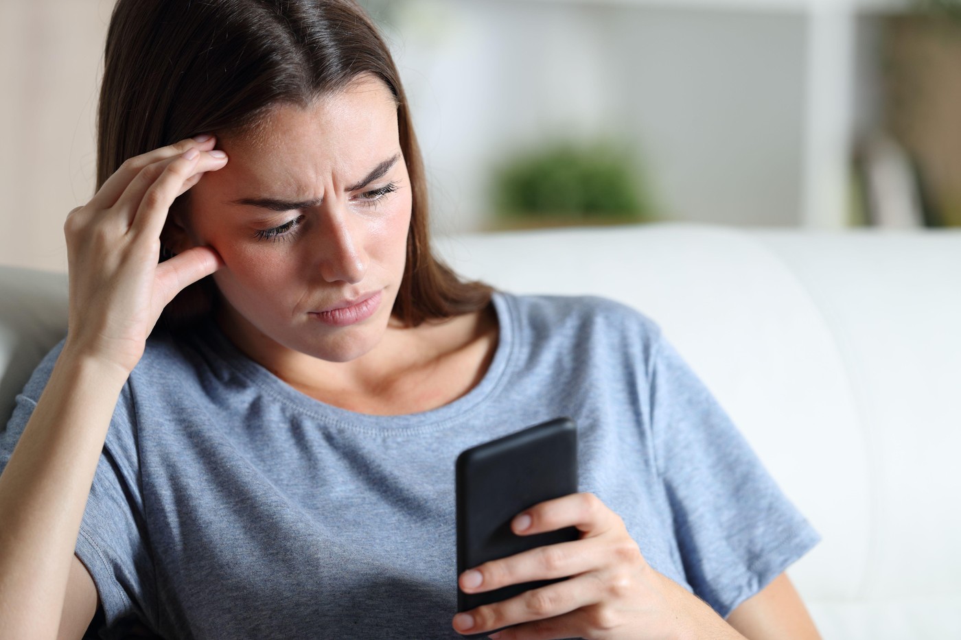 ženska zaskrbljena gleda v telefon