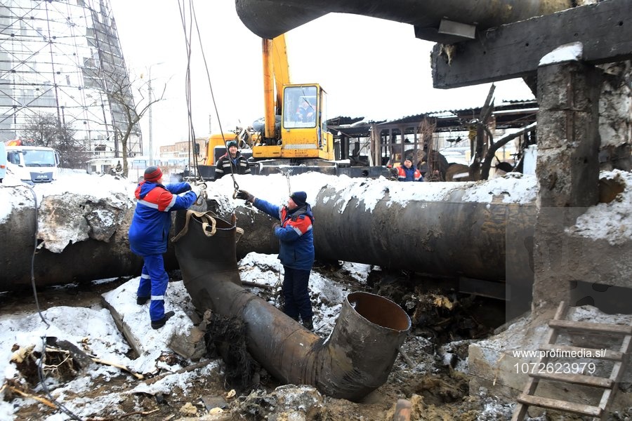Workers get ready to lift a section of a pipe at Kyiv CHPP-4,