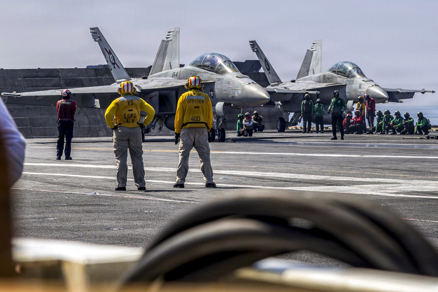 photograph  by the US Navy, two F/A-18F Super Hornets, attached to Strike Fighter Squadron (VFA) 41, prepare to launch from the flight deck of Nimitz-class aircraft carrier USS Abraham Lincoln in the Arabian Sea February 15, 2026.