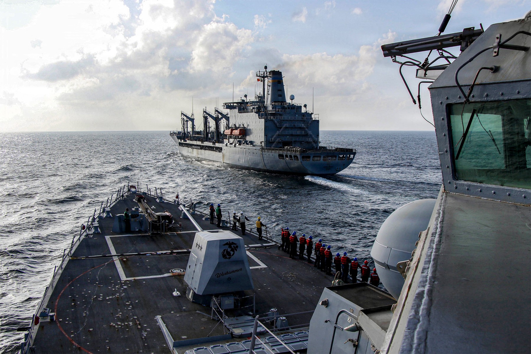 photograph by the US Navy, the Arleigh Burke-class guided-missile destroyer USS Frank E. Petersen Jr. sails alongside fleet replenishment oiler USNS Henry J. Kaiser (T-AO-187), during a replenishment-at-sea in the Arabian Sea February 18, 2026