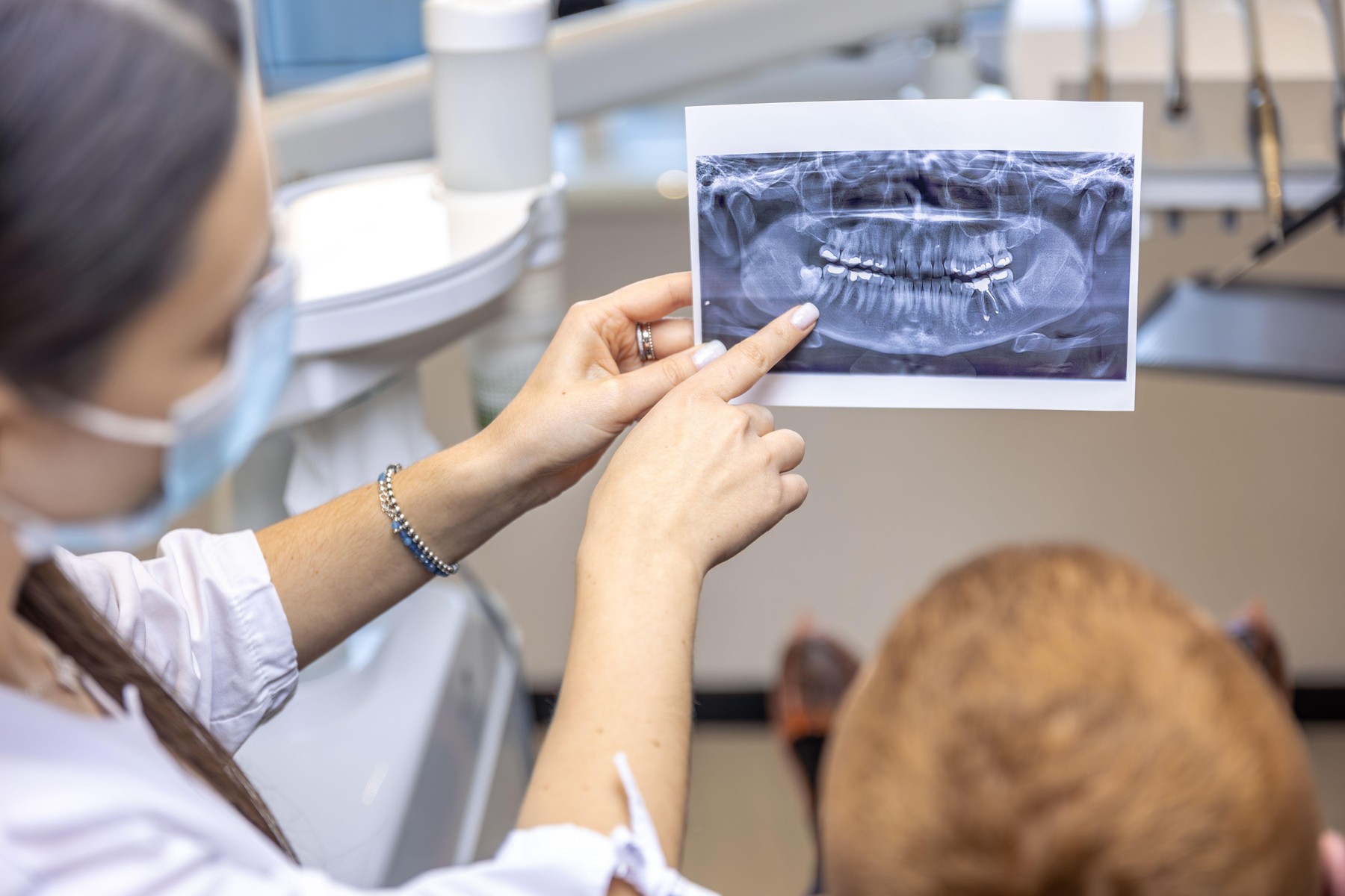 Young female dentist showing a patient a dental x-ray. Dentistry concept. High quality photo. Dentist at work. Dentist and patient. Close up.,Image: 981198821, License: Royalty-free, Restrictions: , Model Release: no