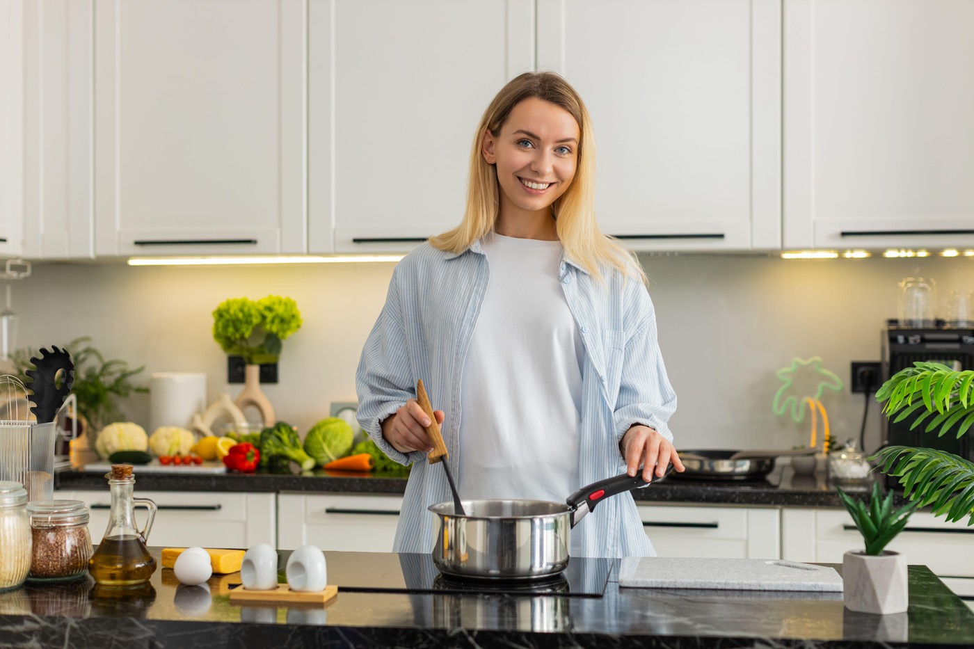ženska v kuhinji kuha z nasmehom