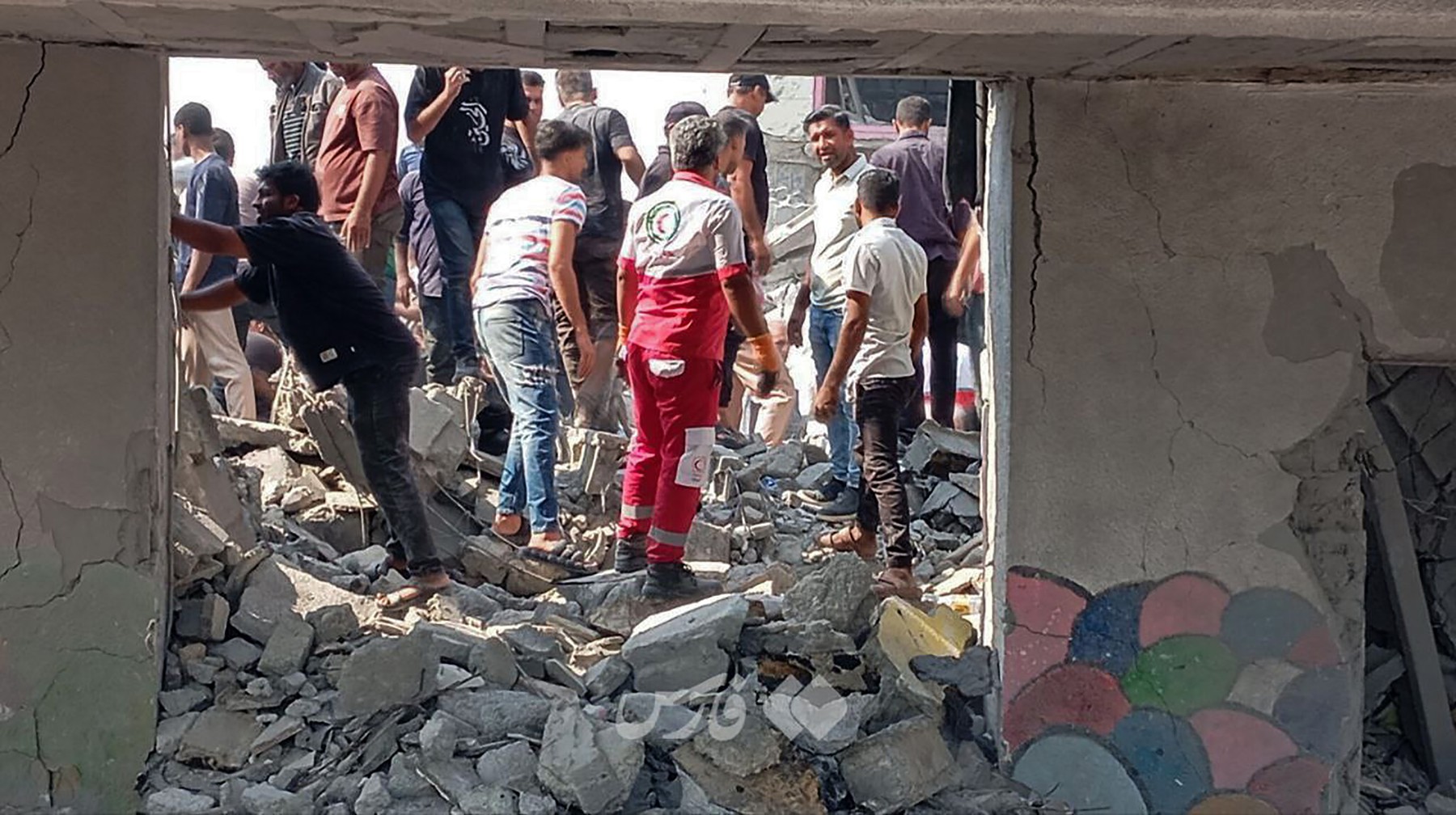 Rescue teams of  , joined by local citizens, are working to pull victims from the rubble of a school destroyed in a U.S.-Israeli airstrike in Hormozgan province,