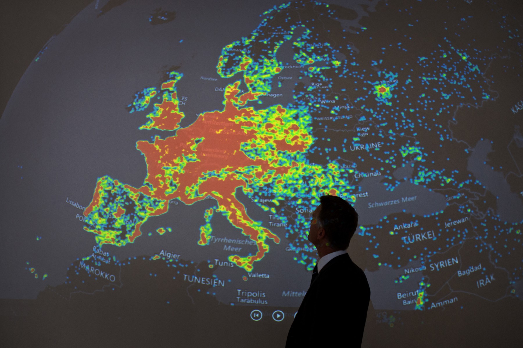 A man stands in front of a picture displaying activities of a so-called "botnet"