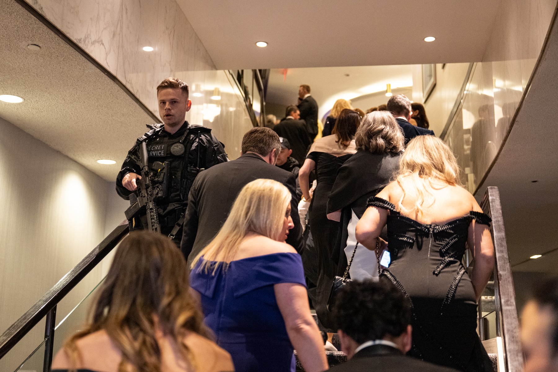 Guests are escorted out of the room at the 2026 White House Correspondents’ Dinner after shots were fired