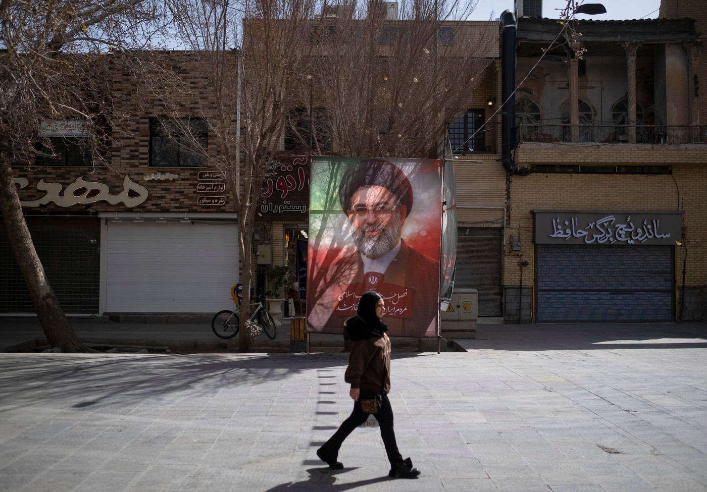 Iranka hodi mimo portreta vrhovnega voditelja Modžtabe Hameneja v Isfahanu